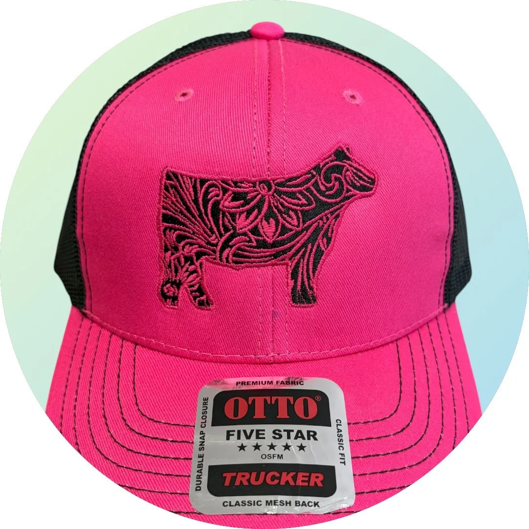 Pink and black trucker cap with a black embroidered outline of a pig on the front, and a sticker on the brim that reads 'OTTO Five Star Trucker'.