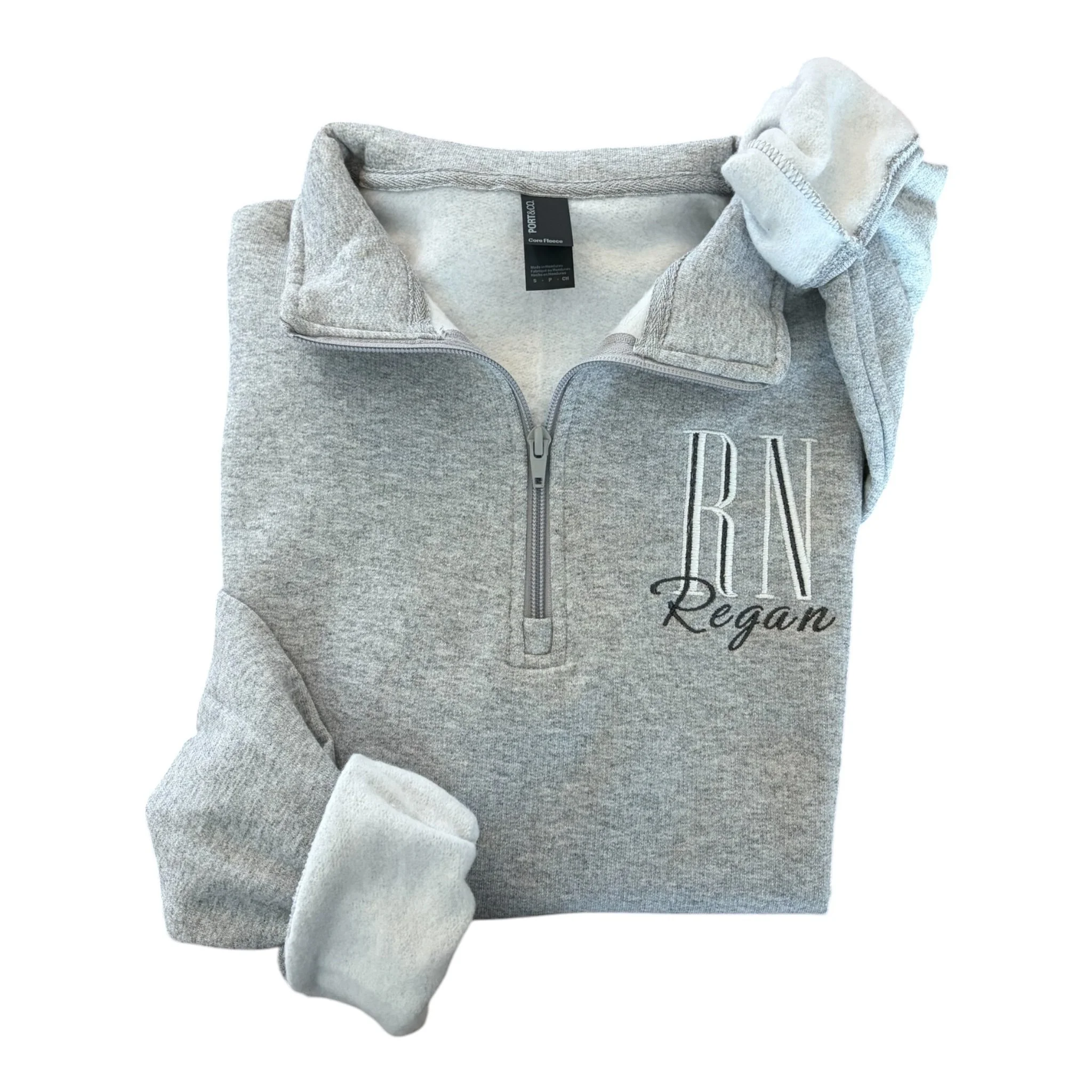 Gray zip-up hoodie with black and white text reading 'Vegan' on the front, folded with the zipper partially open, showing the inner collar.