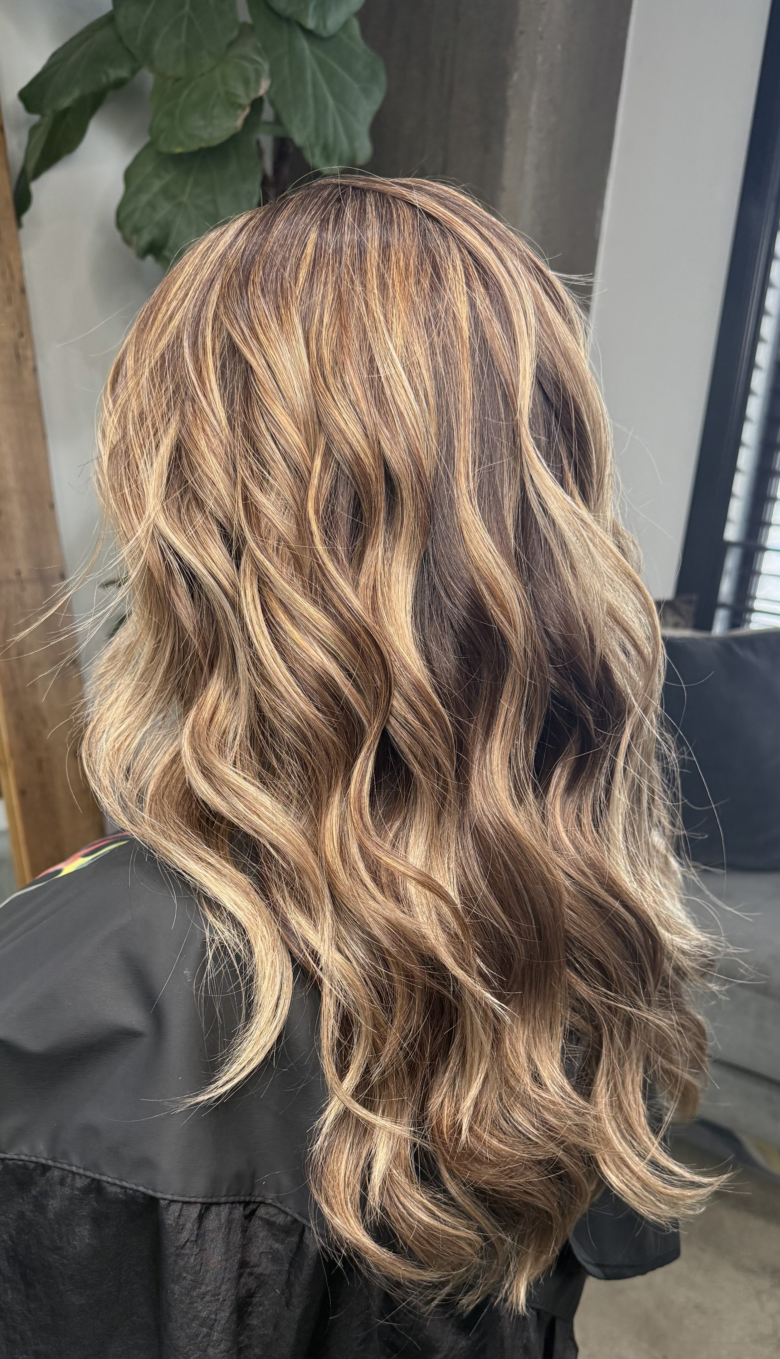 Long women’s haircut with soft layers and natural movement, styled with loose waves