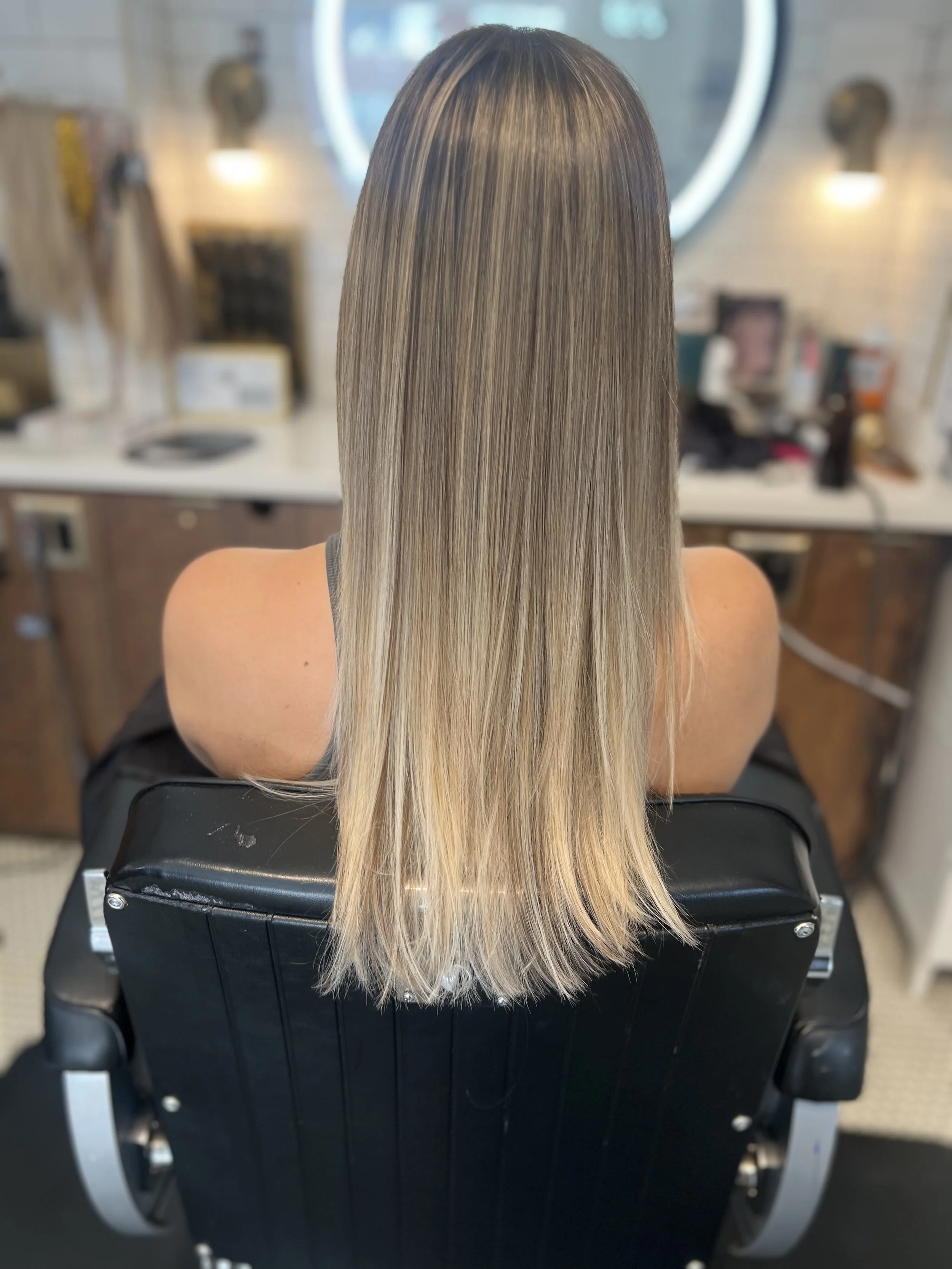 Partial highlights creating soft, dimensional blonde with natural grow-out