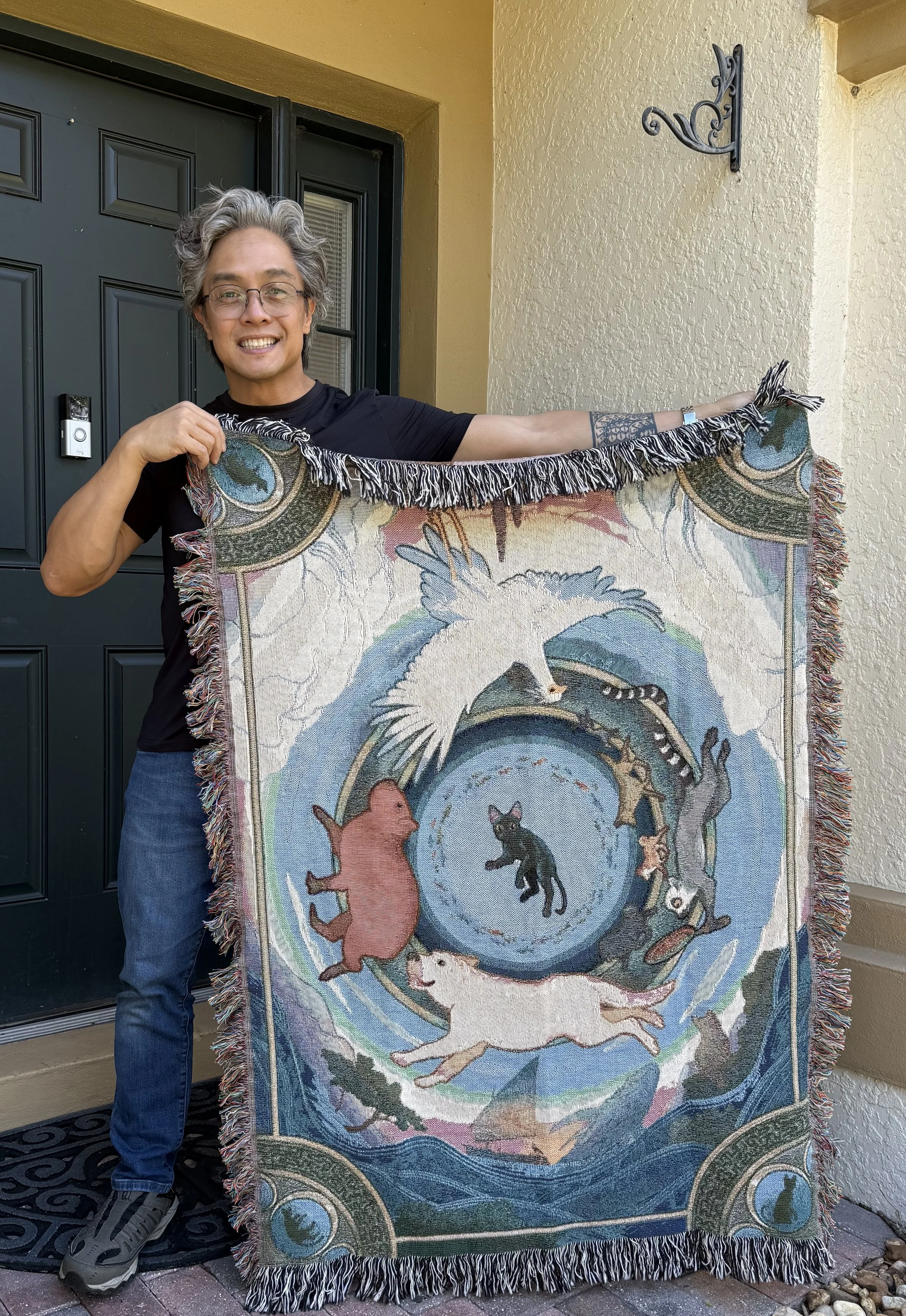 A photo of a person named Eric Calderon holding an official licensed throw blanket for the movie Flow.