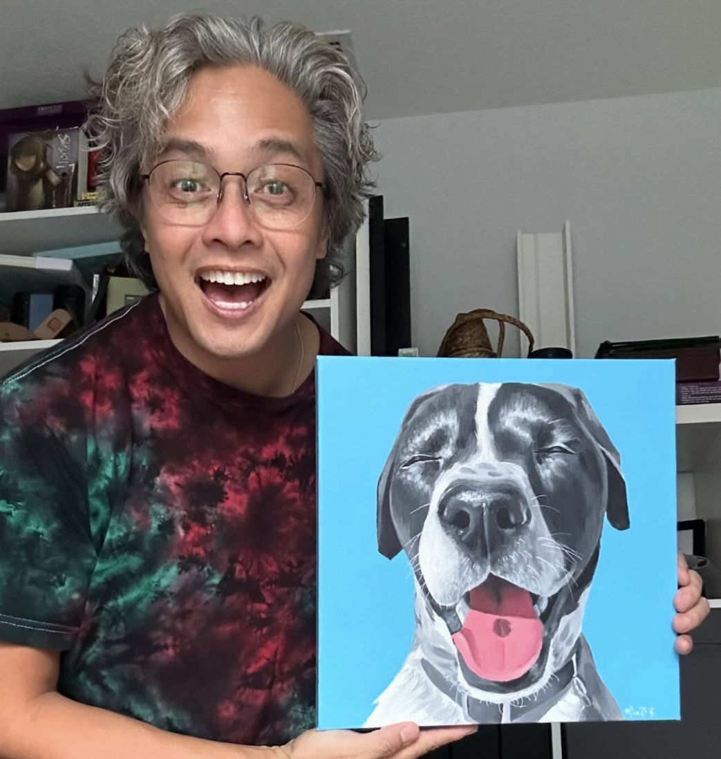 A photo of Eric Calderon with a painting of his dog.