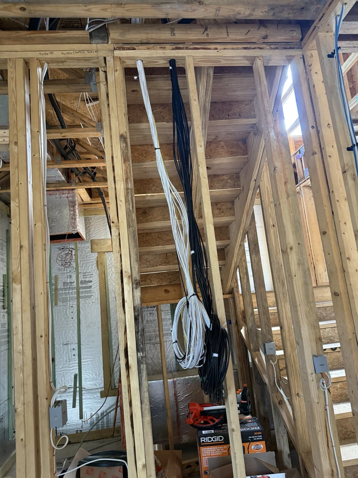 Organized low-voltage cable bundles routed through open framing during a Bold City residential prewire phase