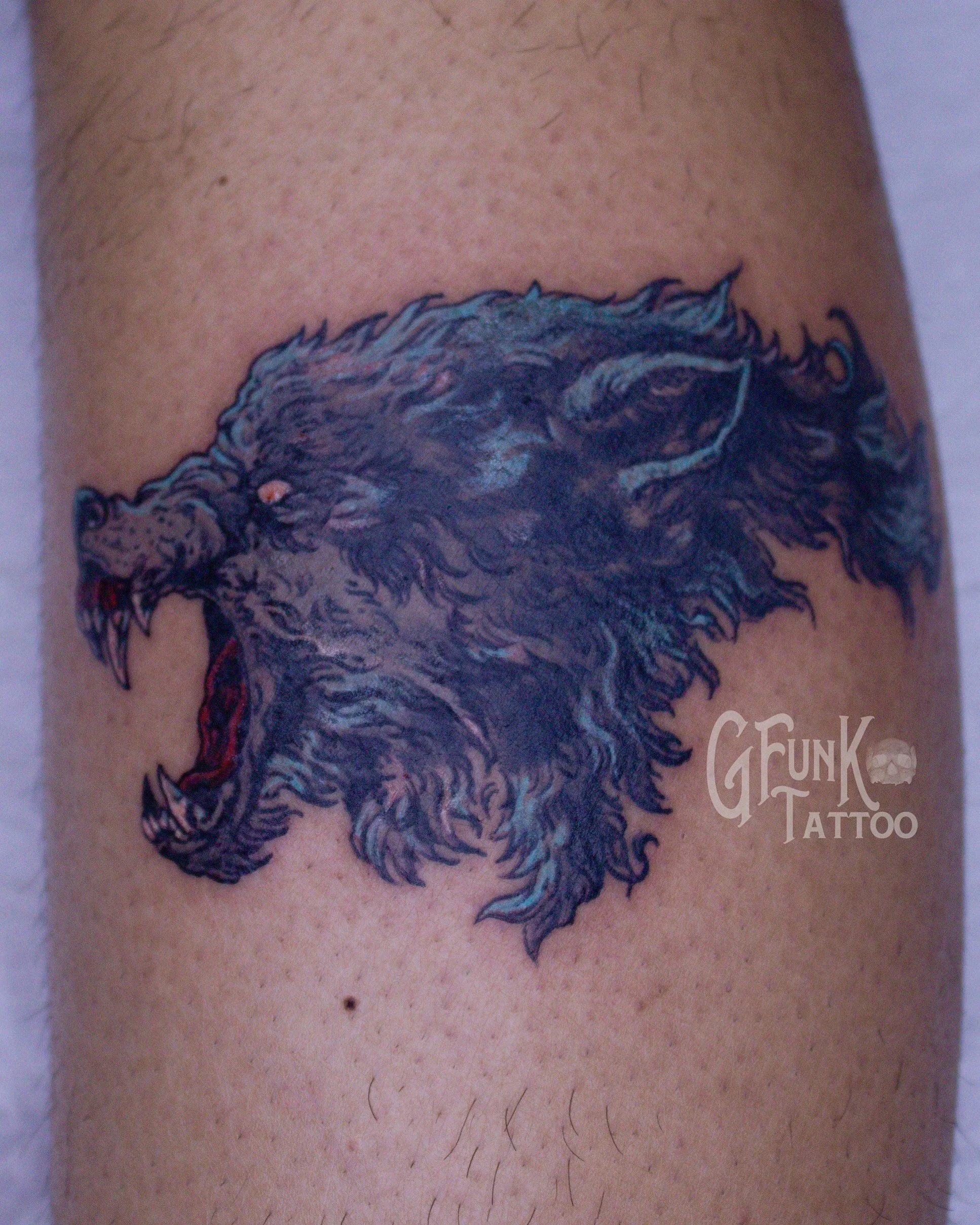 Close-up of a tattoo of a wolf on a person's skin.