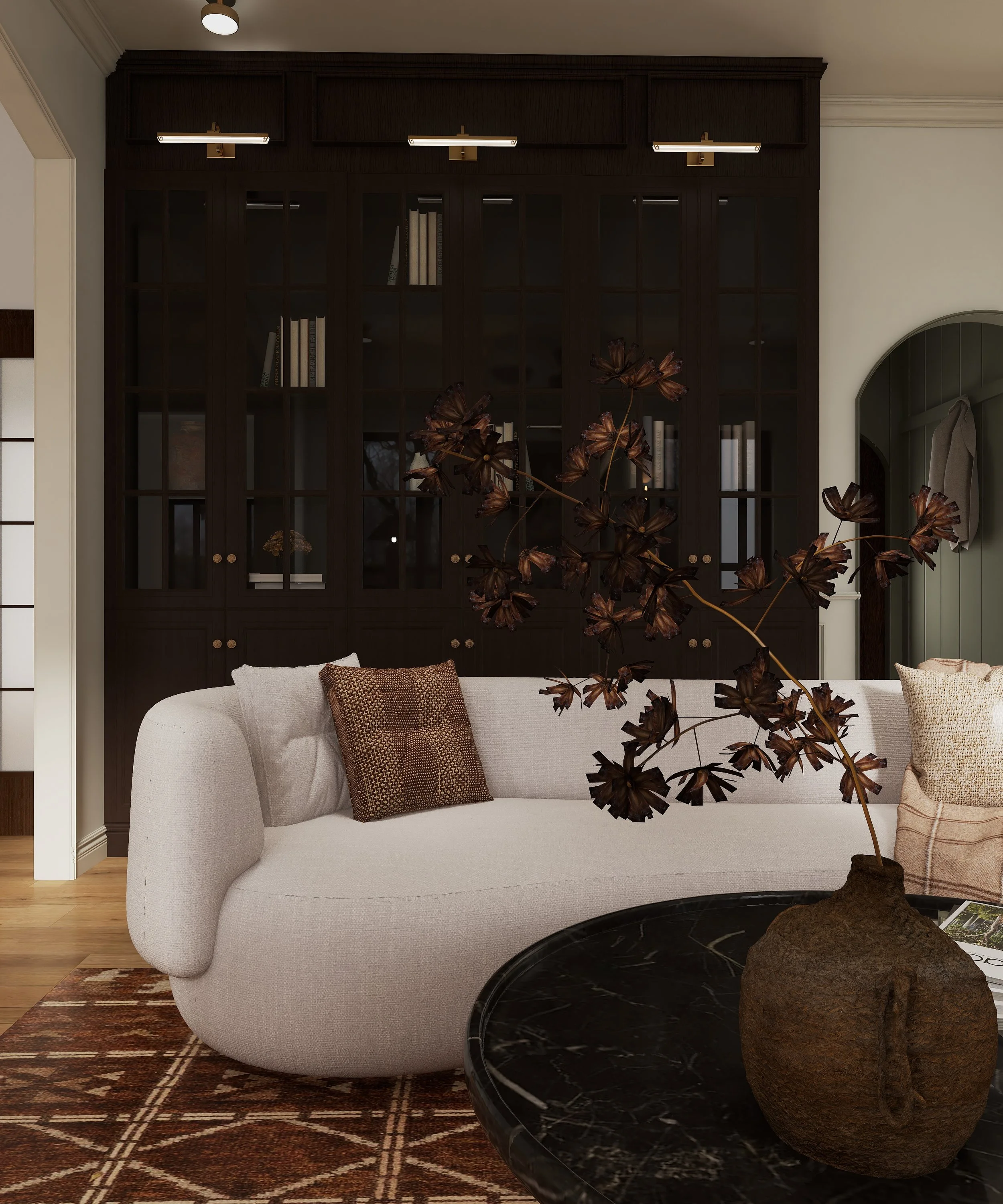 Living room with a white sofa, brown patterned cushions, a dark wooden cabinet with glass doors, a black marble coffee table with decorative rocks, and dark foliage plants.
