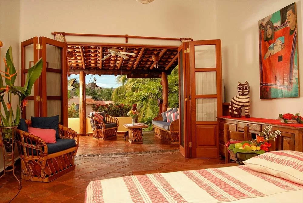 Sala abierta conectada con una terraza tropical en una residencia de Zihuatanejo.