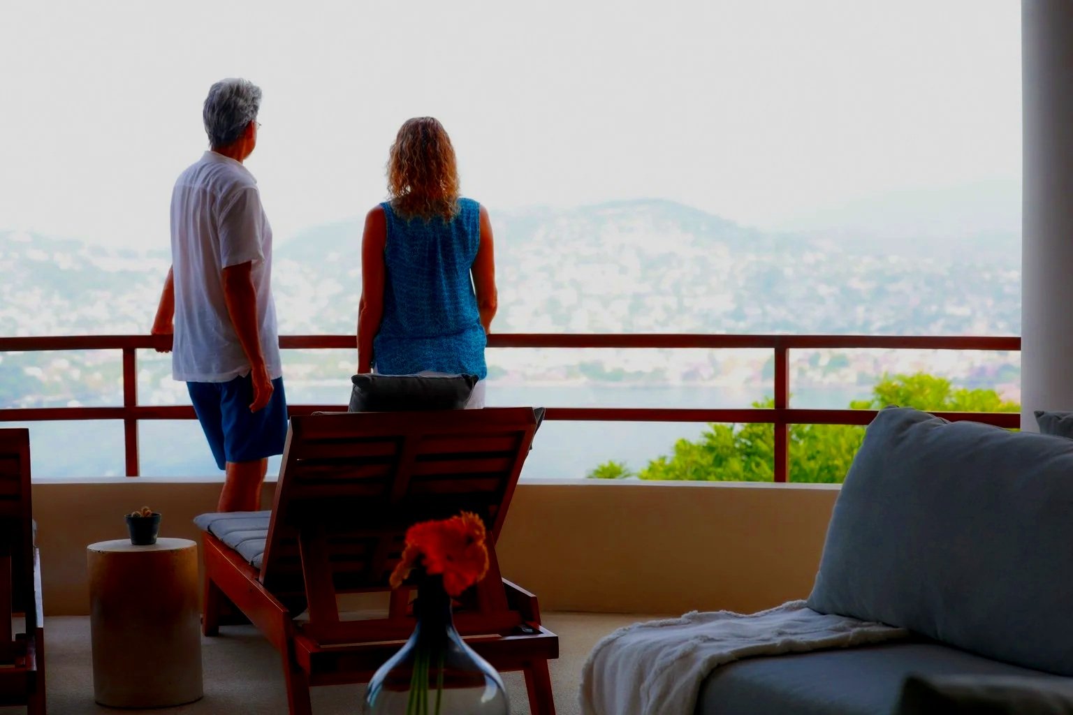 Pareja observando el mar y el paisaje desde la terraza de una residencia en Zihuatanejo, México.