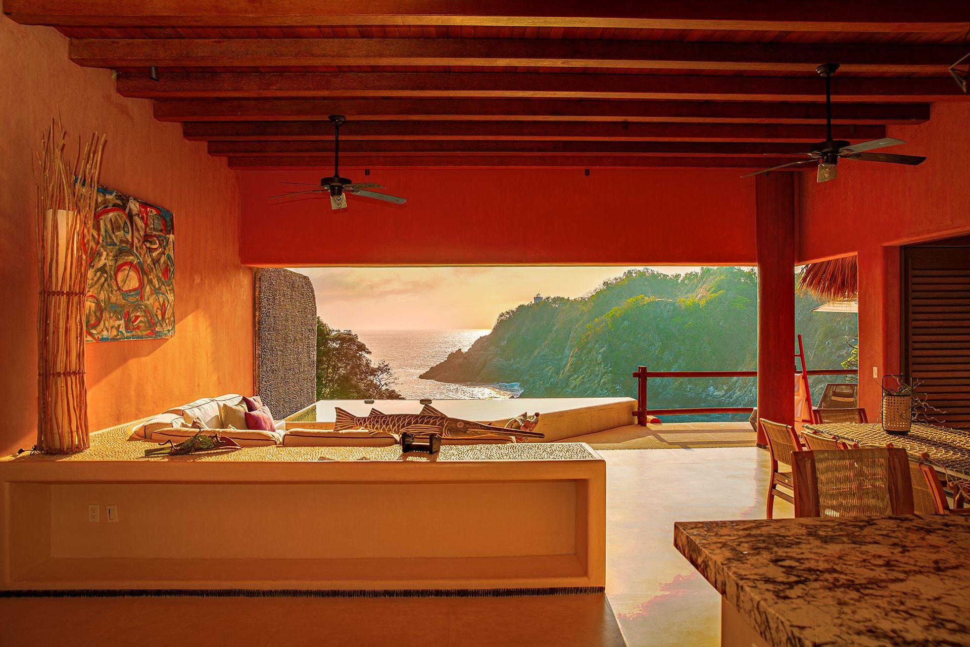 Terraza sombreada y espacios interiores con luz natural en una residencia costera de Zihuatanejo.