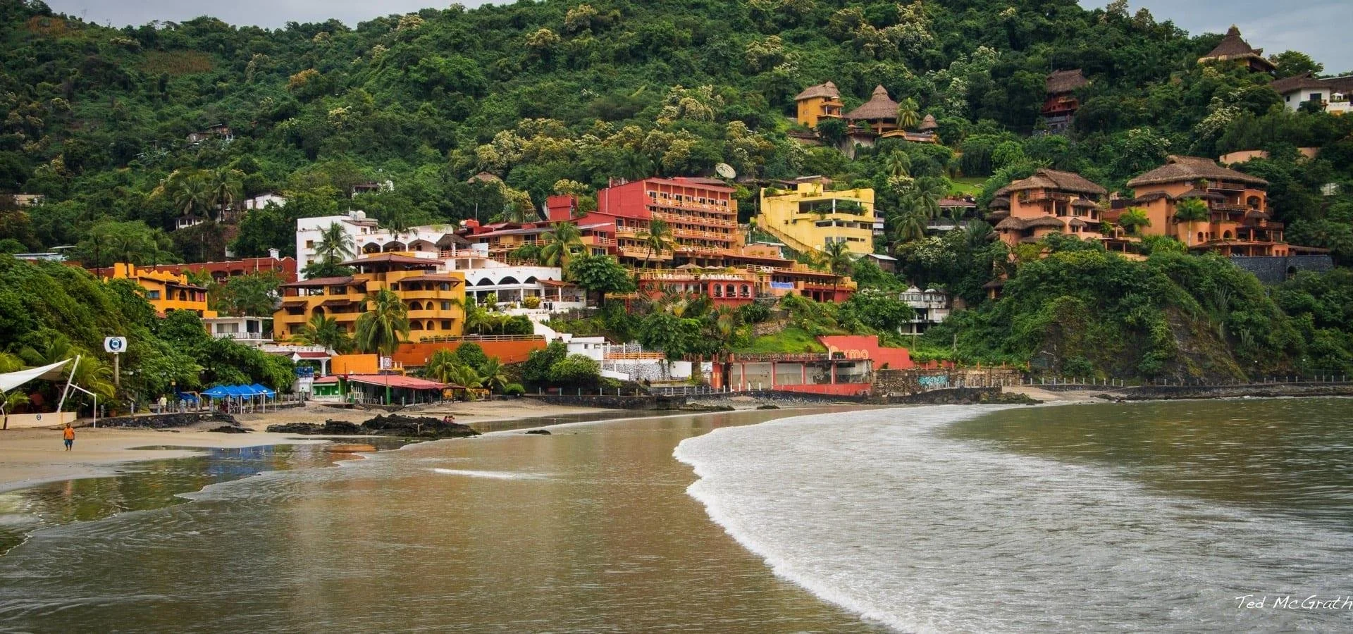 Panoramic view of Zihuatanejo's coastline showing beaches, hillsides and residential areas along the Pacific Ocean.