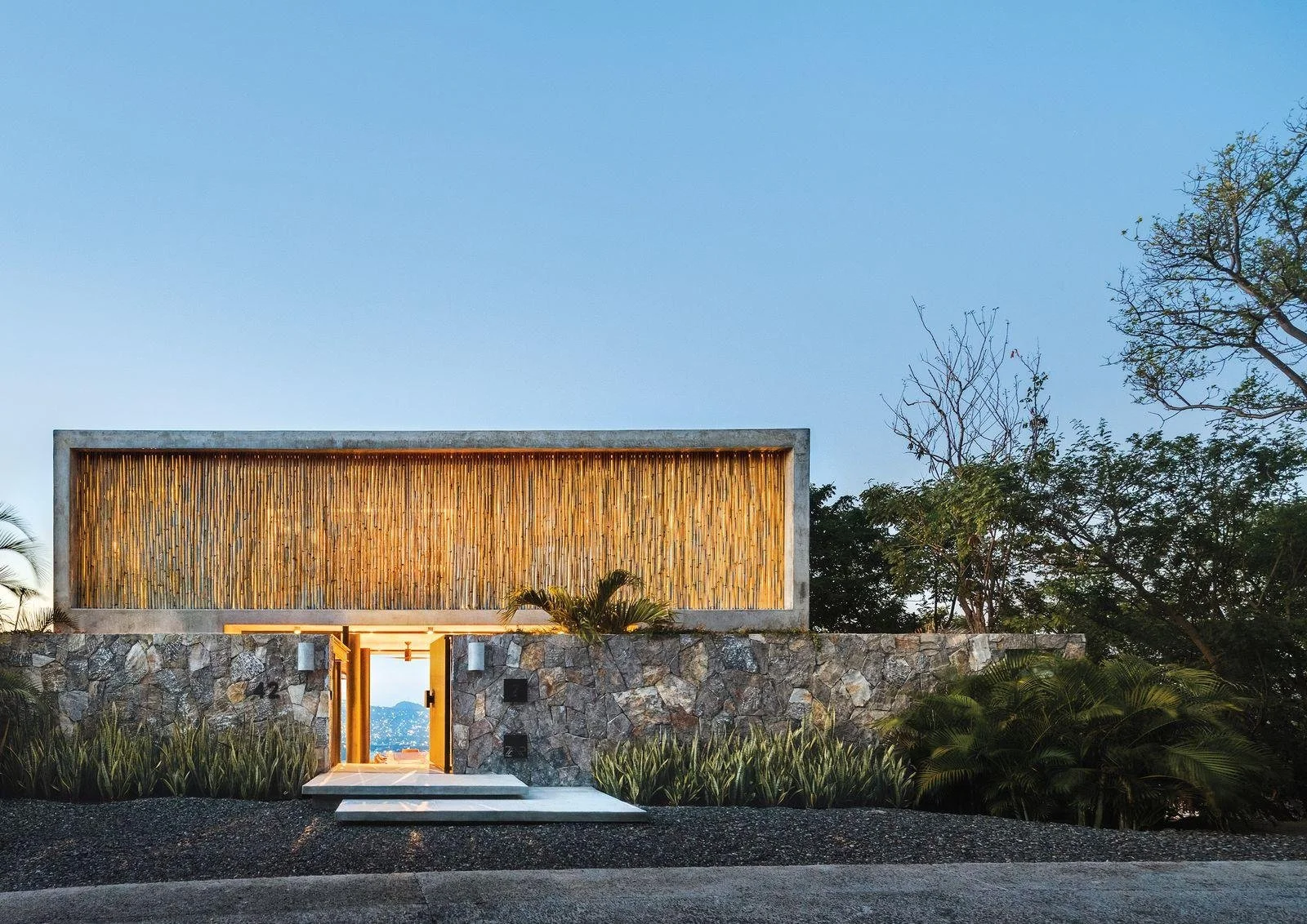 Detalles arquitectónicos de piedra natural, madera y acabados con textura en una residencia costera.