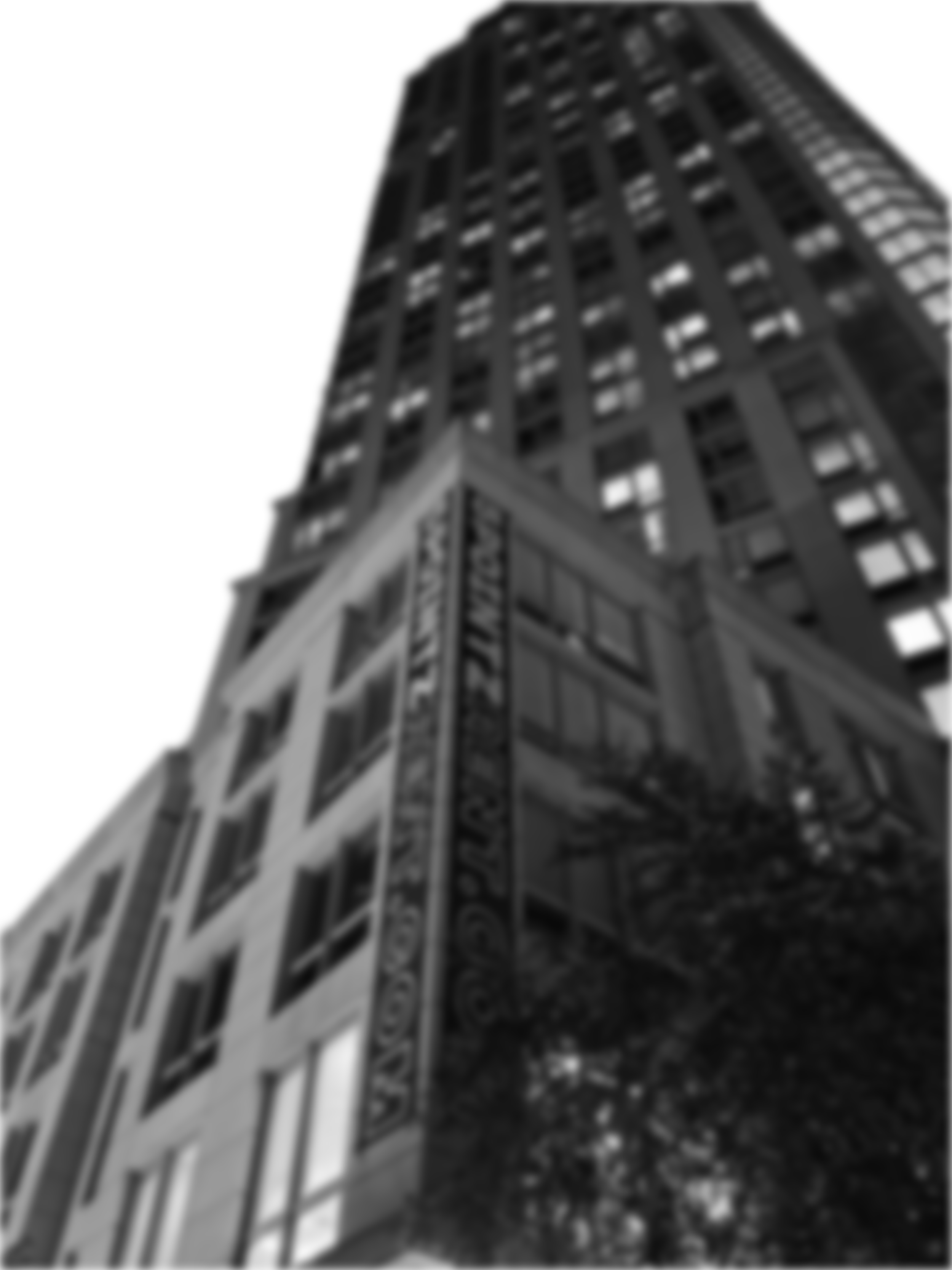 A tall, multi-story building with a sign that reads 'NATIONAL BANK' on the corner. The building has numerous windows and a modern architectural style, photographed from a low angle, looking up at the structure.