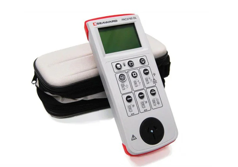 A handheld medical or industrial device with buttons and a large display, resting on a zippered carrying case.