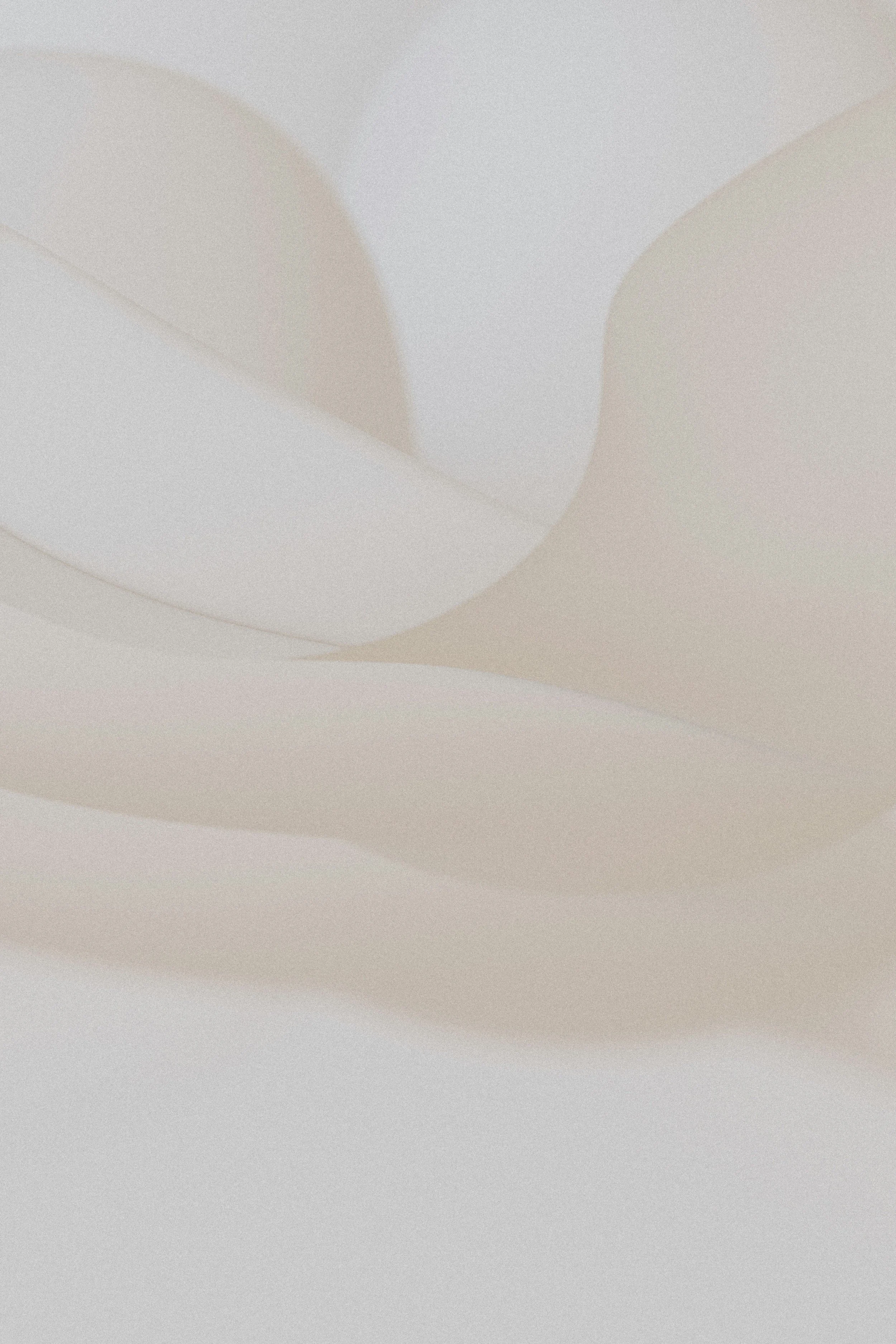 Abstract soft cream-colored wave-like shapes.