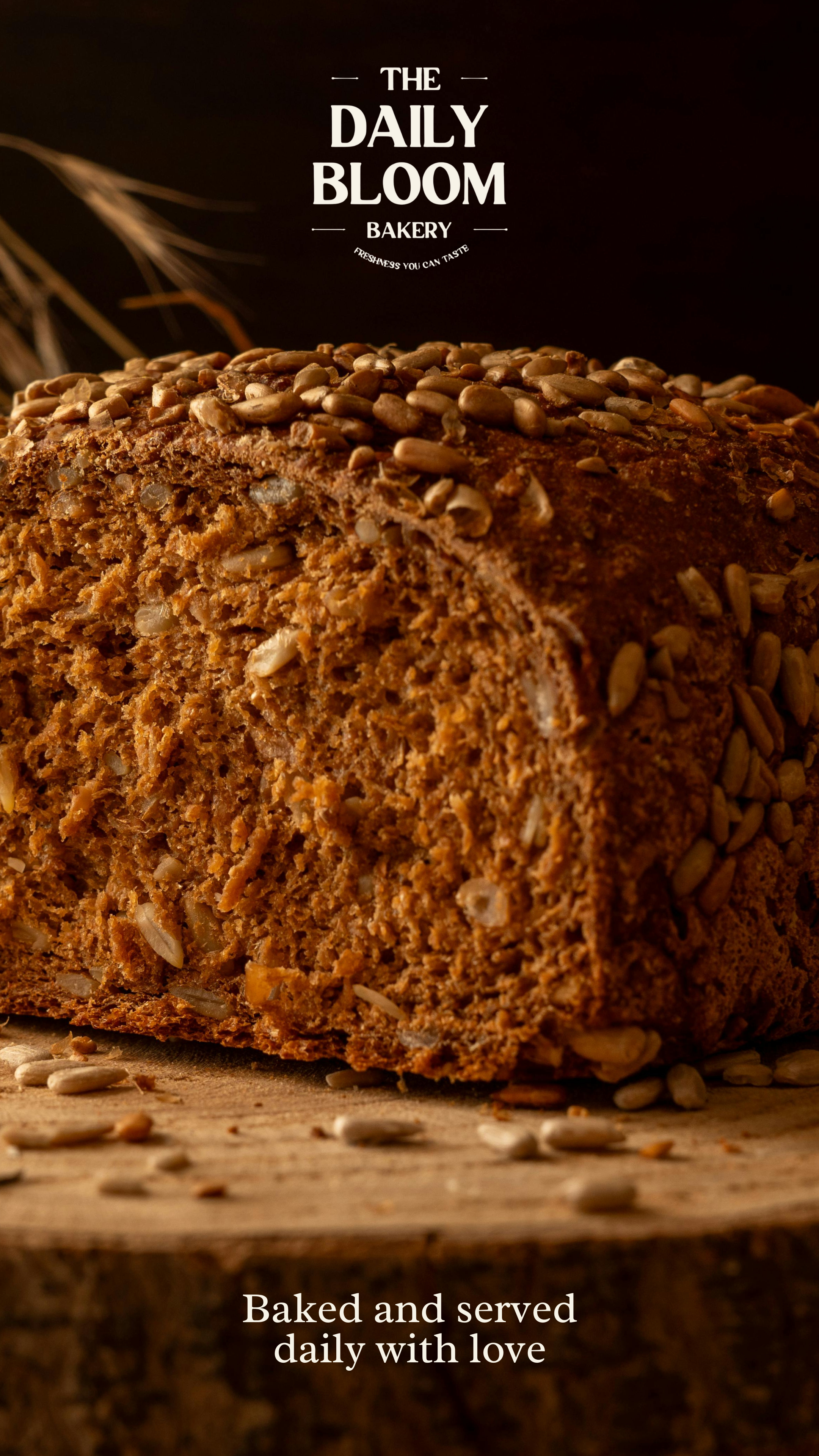 Close-up of a loaf of bread with sunflower seeds on top, resting on a wooden surface, with background text reading "The Daily Bloom Bakery" and "Baked and served daily with love."