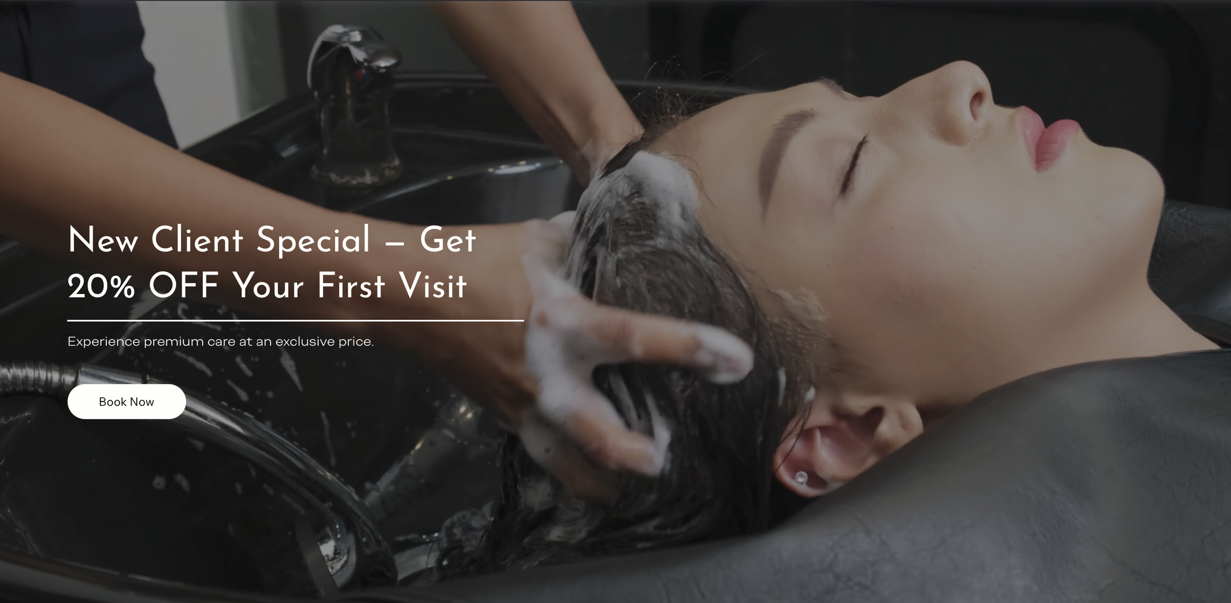 A woman with closed eyes getting her hair washed at a salon, with a bar of soap or shampoo lathering on her hair and a person caring for her.