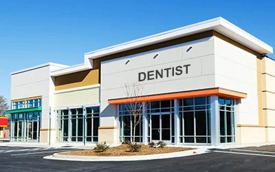 Exterior of a modern building with the sign 'DENTIST' on the front.
