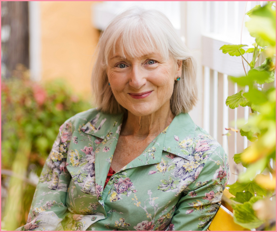 Woman over 60 looking hopeful sitting in her garden on a yello garden bench