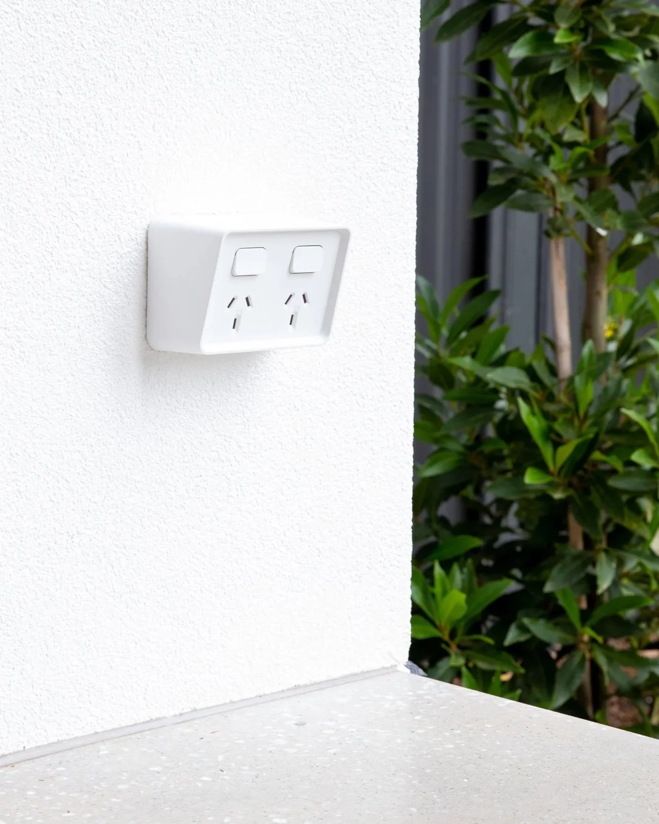 photo of a white outdoor powerpoint next to a garden