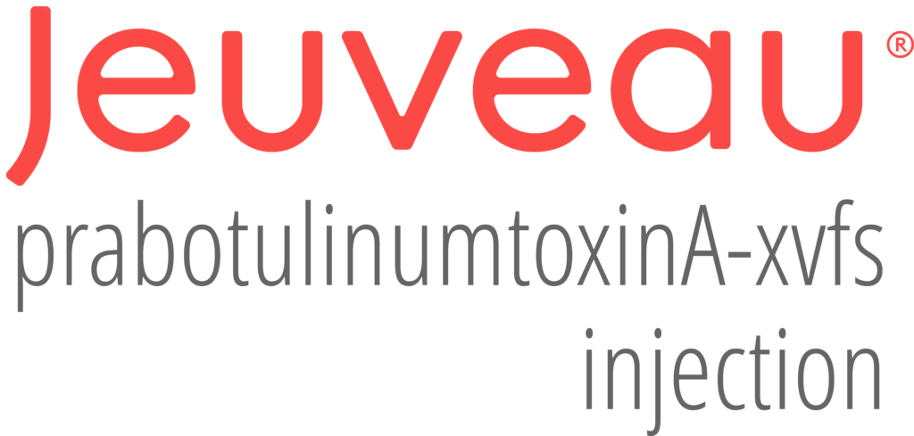 A protest or outdoor event with a large red and black banner in the background. People are standing behind a barrier with some wearing masks.