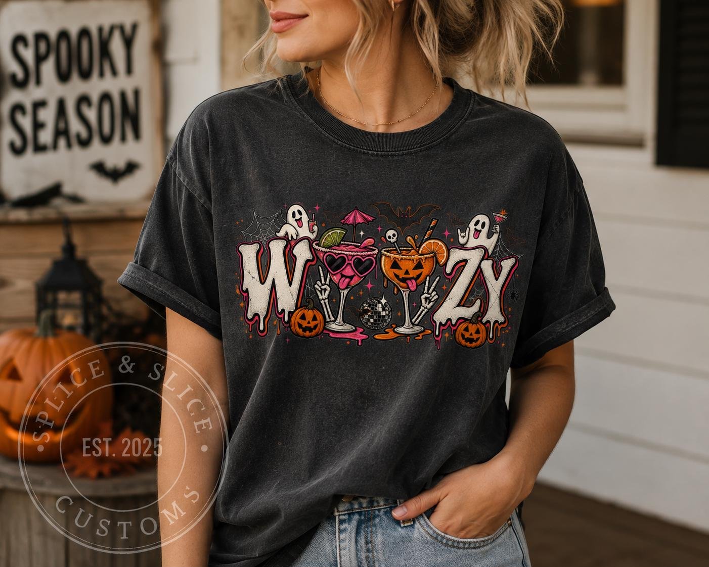 A charcoal gray T-shirt with a Halloween graphic featuring the word WOOZY decorated with ghosts, cocktails, and pumpkins.