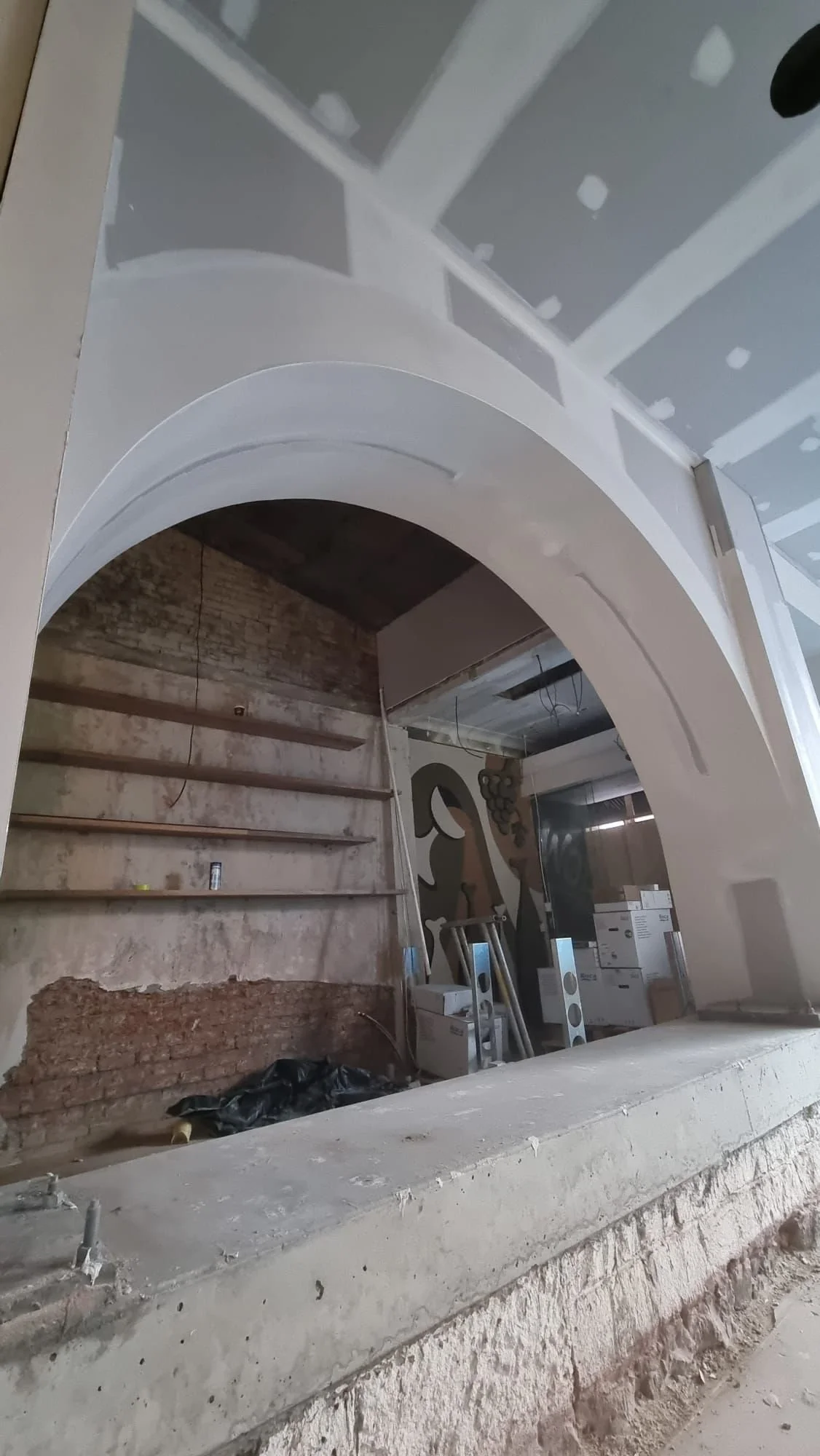 Interior of a building under construction with exposed walls, unfinished surfaces, and construction materials, a project by JAYQ Plaster & Trades.