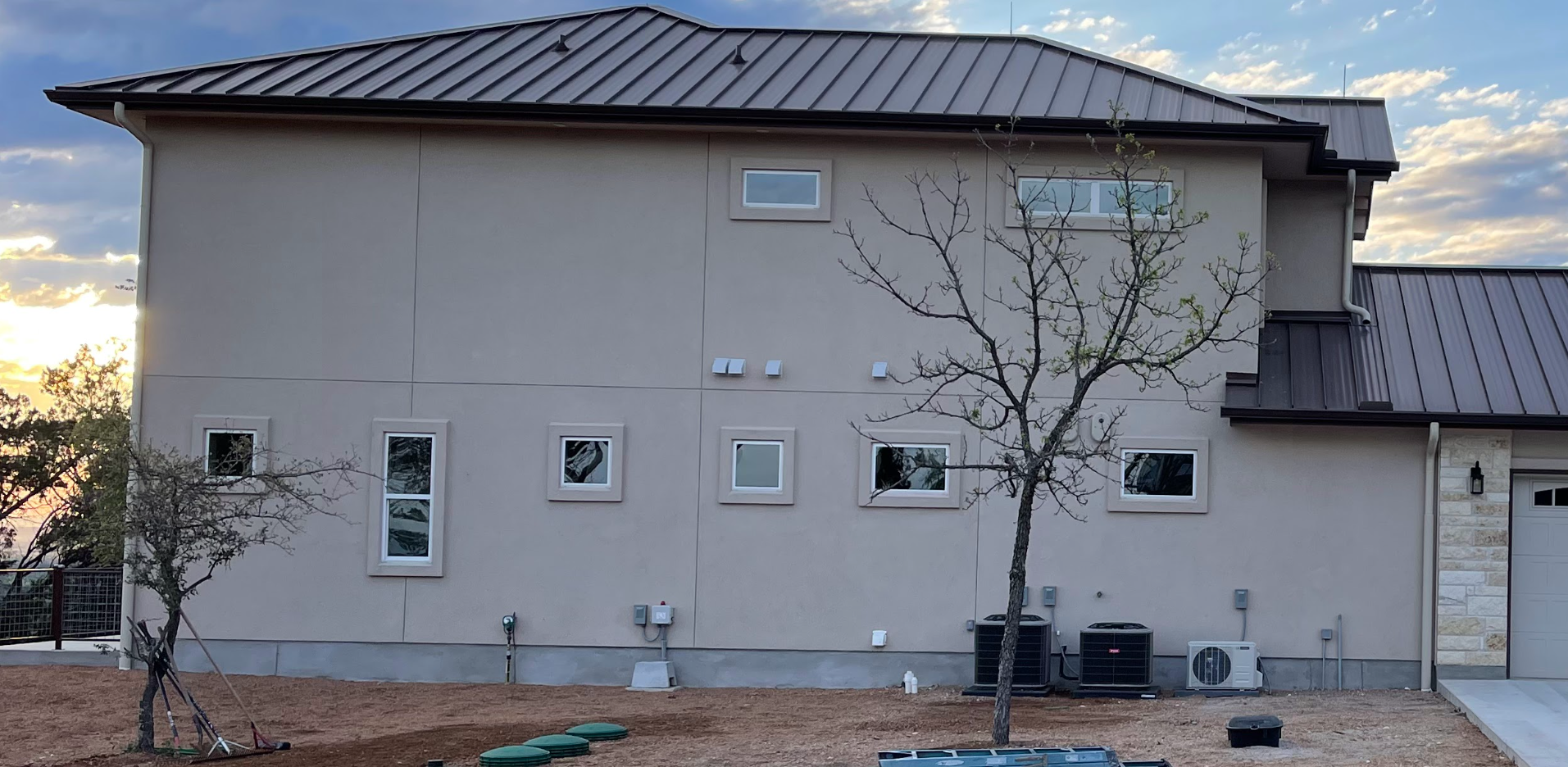 High-capacity seamless aluminum gutters with custom round downpipes installed for rainwater harvesting by Reinewater Solutions in Marble Falls.