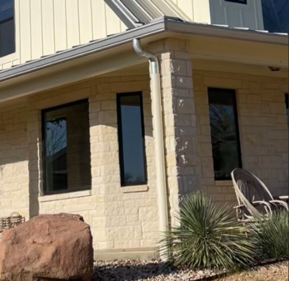 Heavy-duty seamless aluminum gutters with precision round downpipes and high-volume collection transitions installed by Reinewater Solutions in Burnet Co.