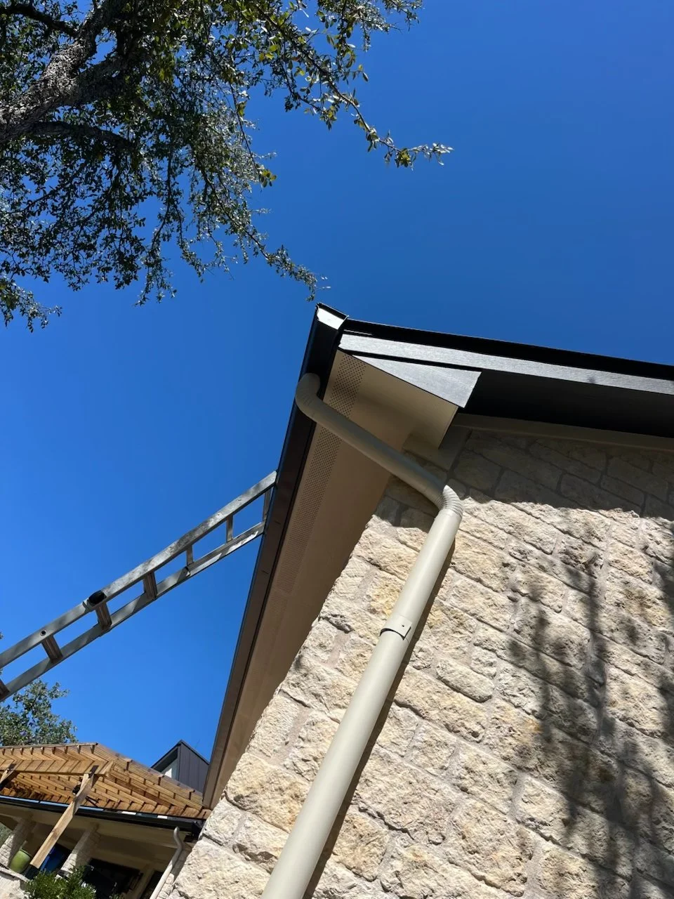 Best Custom seamless aluminum gutters with 4 inch round downspouts for rainwater harvesting, installed by Reinewater Solutions in Burnet Co.