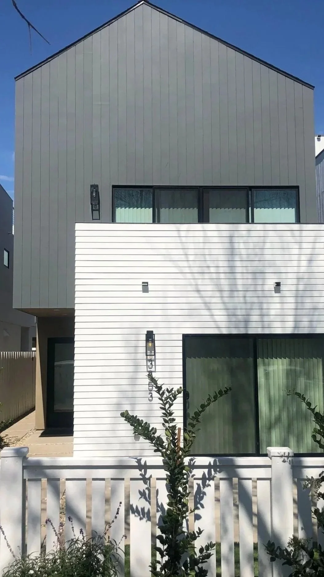 new build modern home exterior with large windows and clean architectural design in San Diego