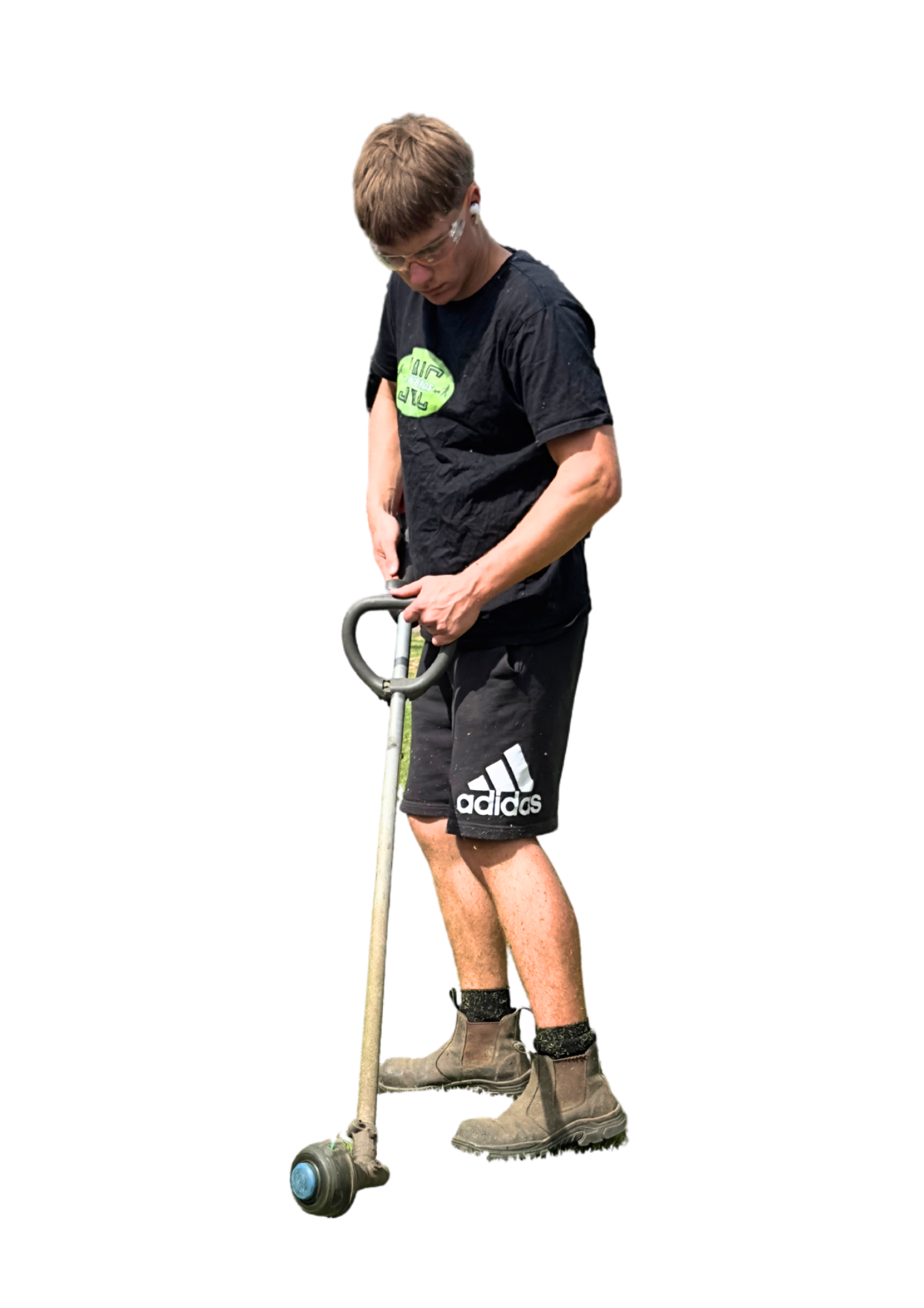 A young man standing and looking down, holding a pump roller coaster car, wearing safety glasses, a black t-shirt, black shorts, and work boots.