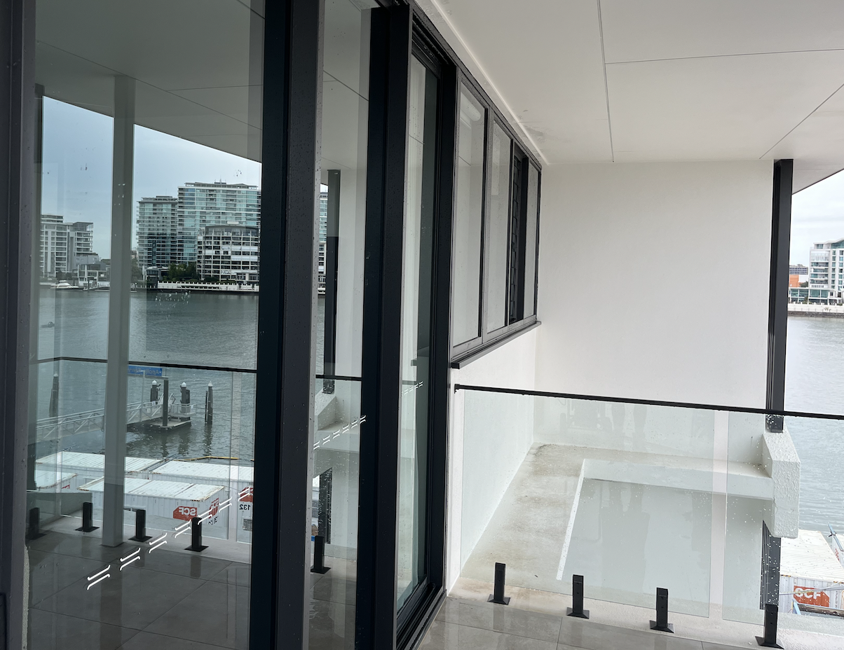 Modern balcony overlooking a waterway with multiple high-rise buildings in the background.