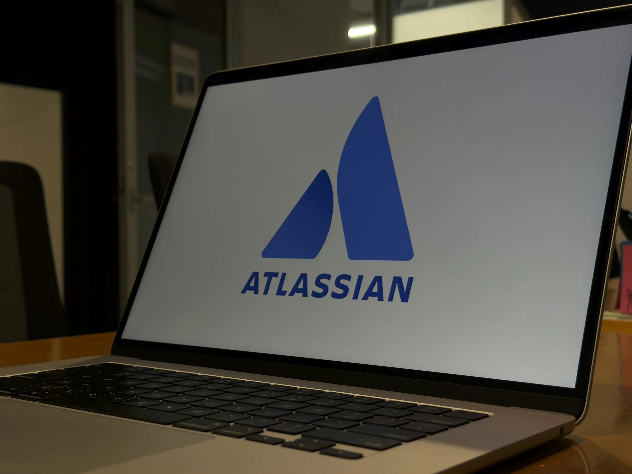 Laptop displaying the Atlassian logo in an office setting.