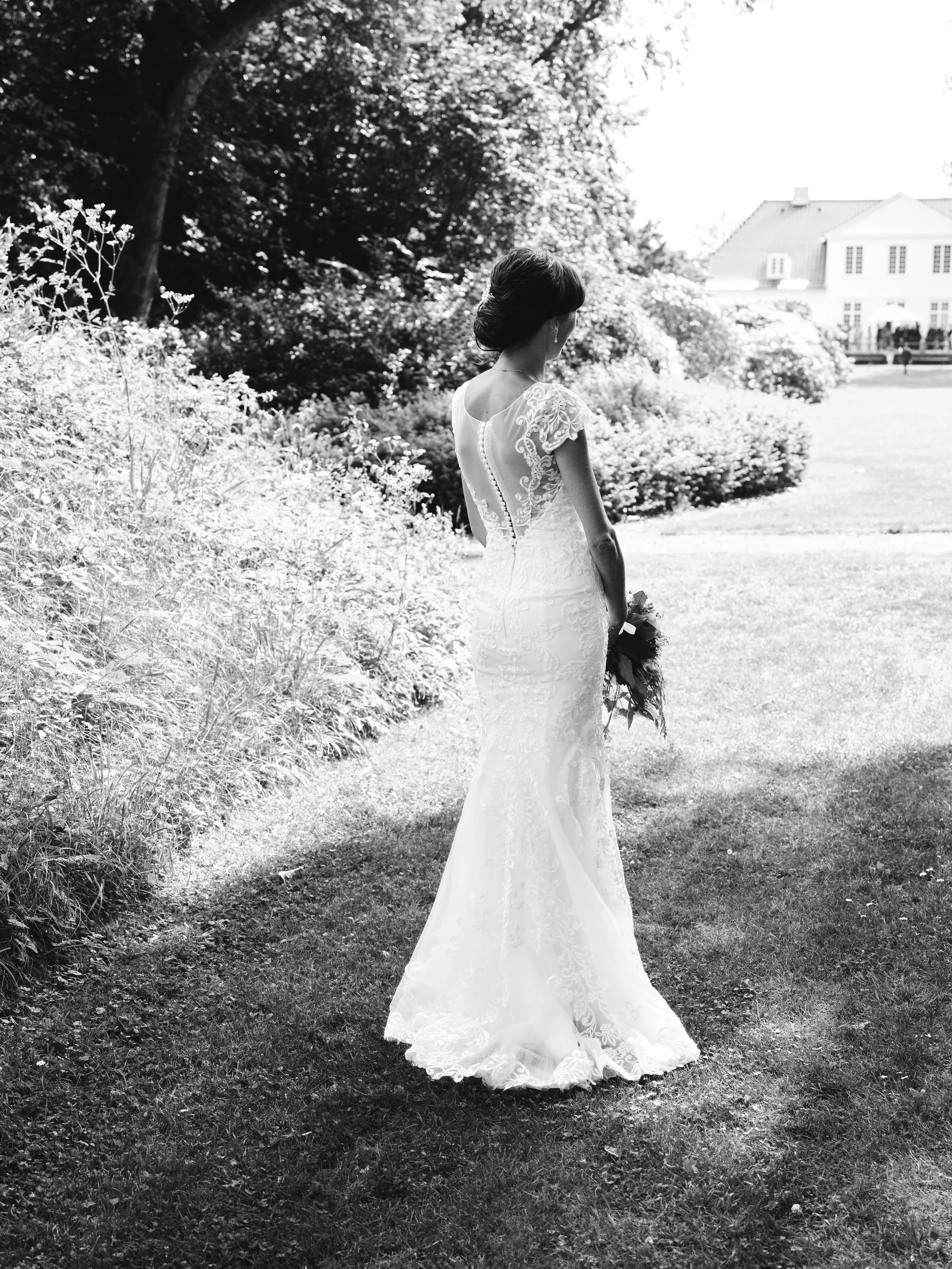 A woman in a wedding dress holding a bouquet of flowers indoors.