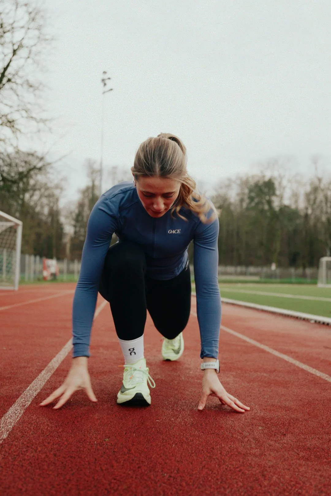 foto von hanna rabisch auf einer roten laufstrecke und in startposition für einen sprint.