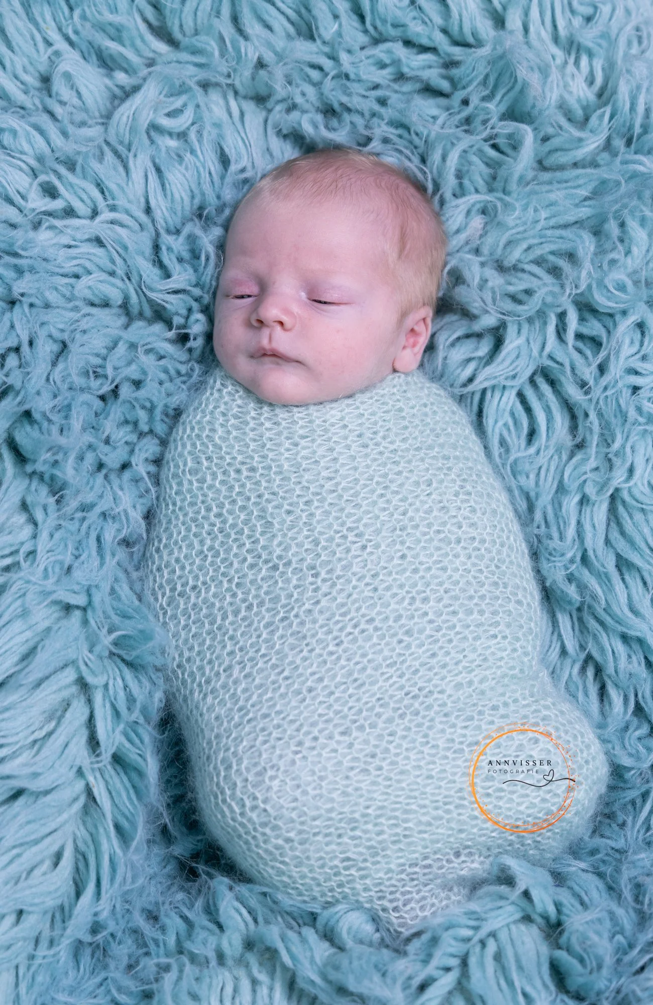 Wrapped baby in een blauwe wrap op een blauwe achtergrond