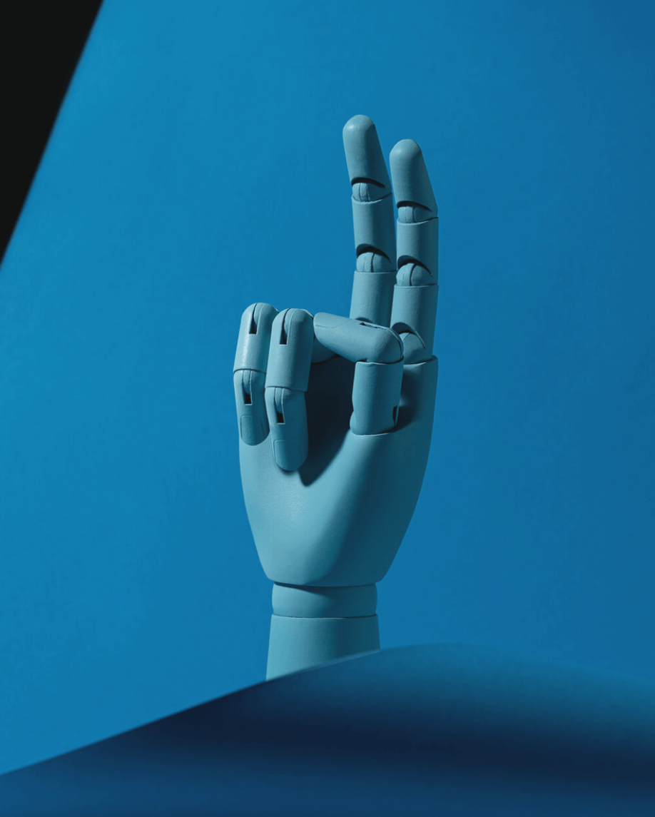 A blue wooden hand making a finger cool gesture against a blue background.