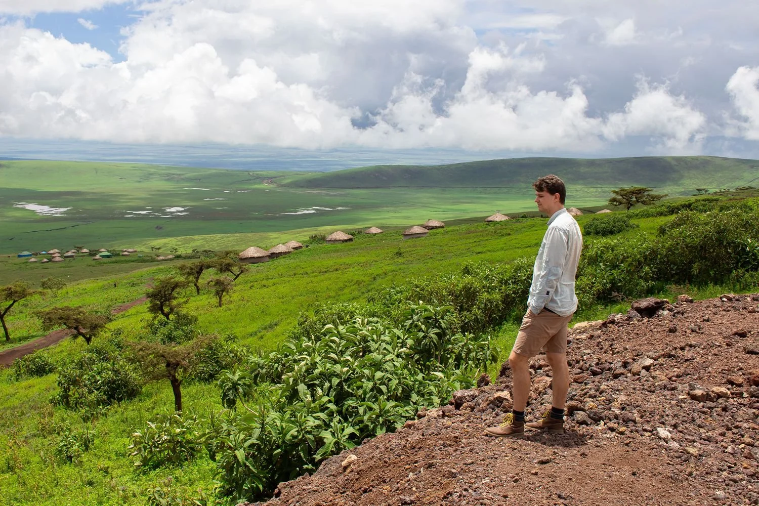 Man kijkt uit over een vlakte met Afrikaanse hutten, in de Ngorongoro-krater in Tanzania tijdens een safari.