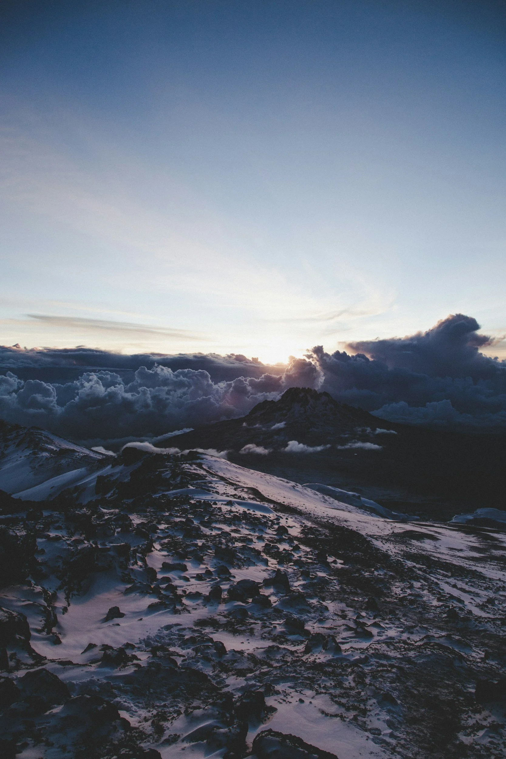 Natuur landschap met sneeuw bedekte bergen en een heldere lucht met wolken tijdens de zonsopgang of zonsondergang.