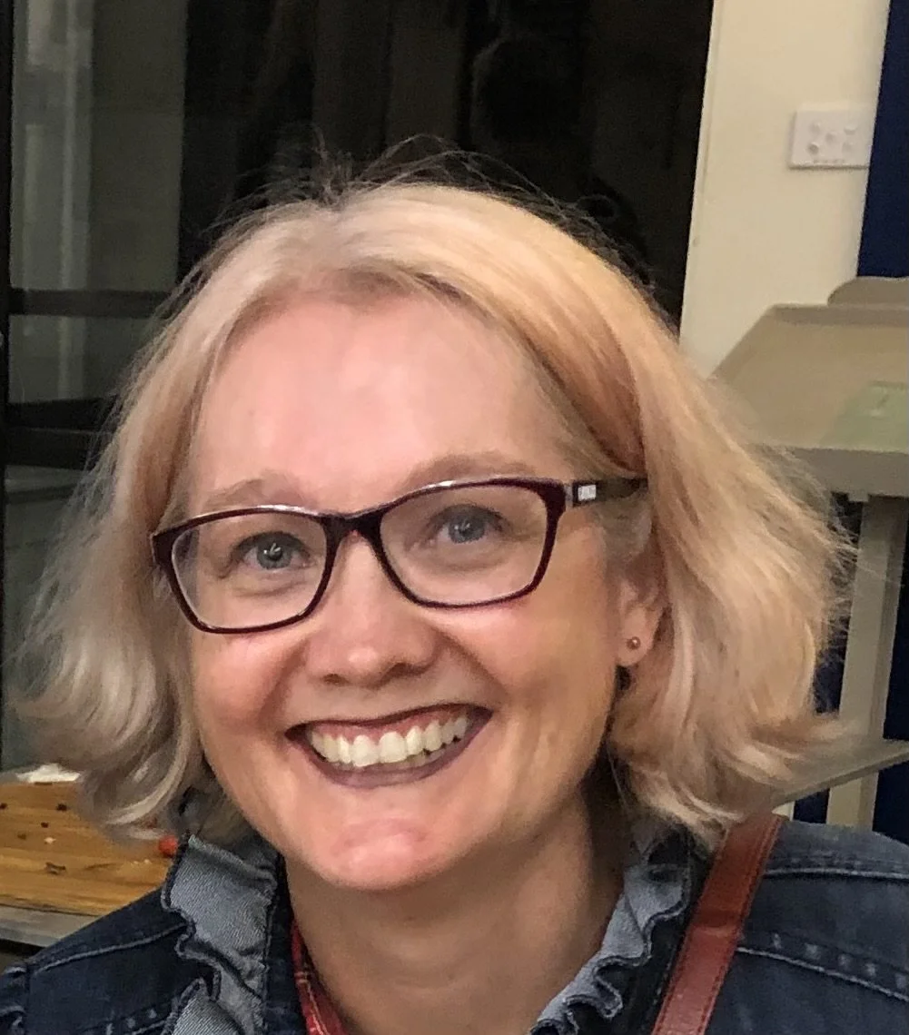 A smiling middle-aged woman with glasses