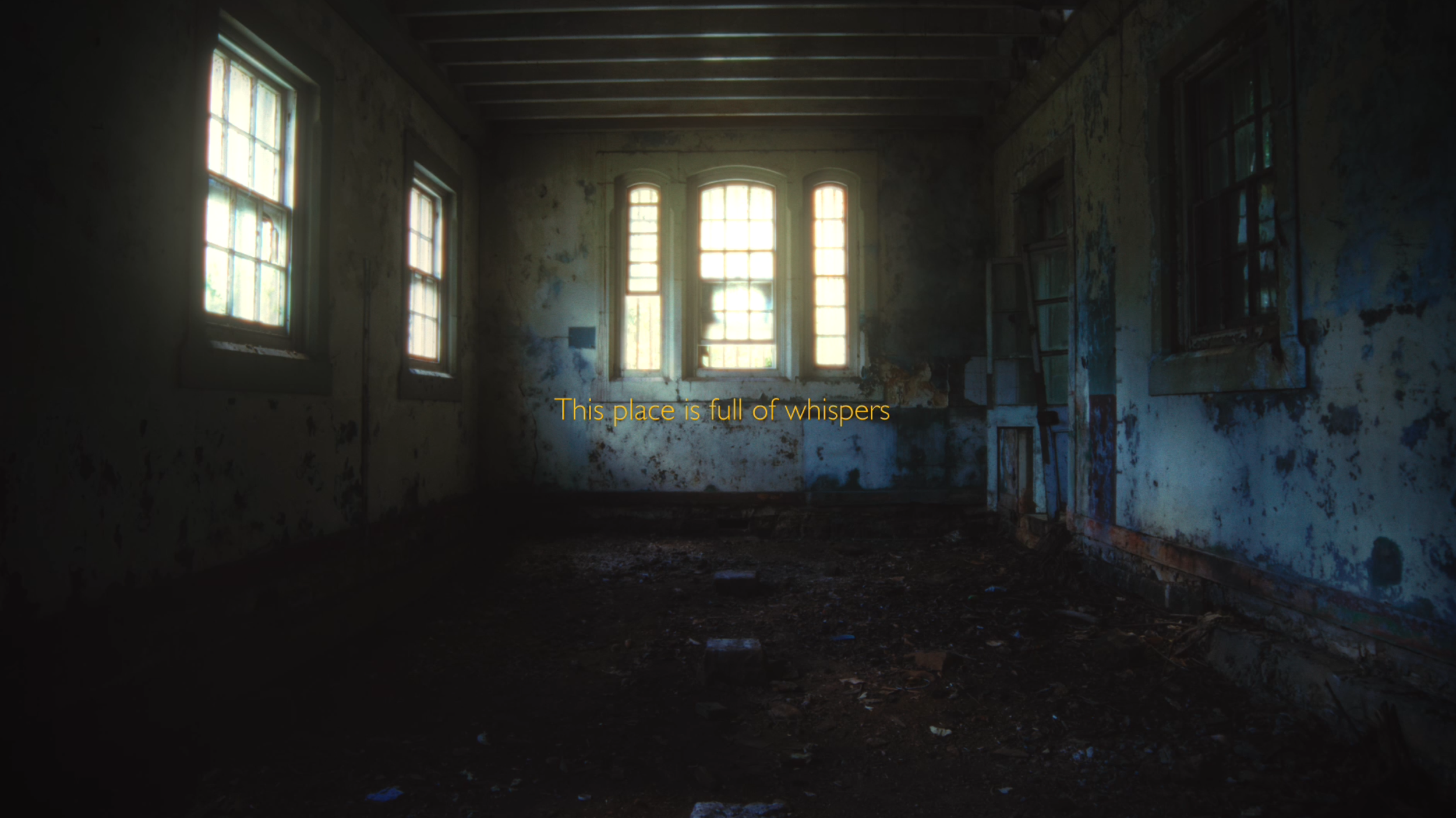 An abandoned room with peeling walls, dirt on the floor, and broken-down windows letting in light. Overlaid text reads 'This place is full of whispers'.