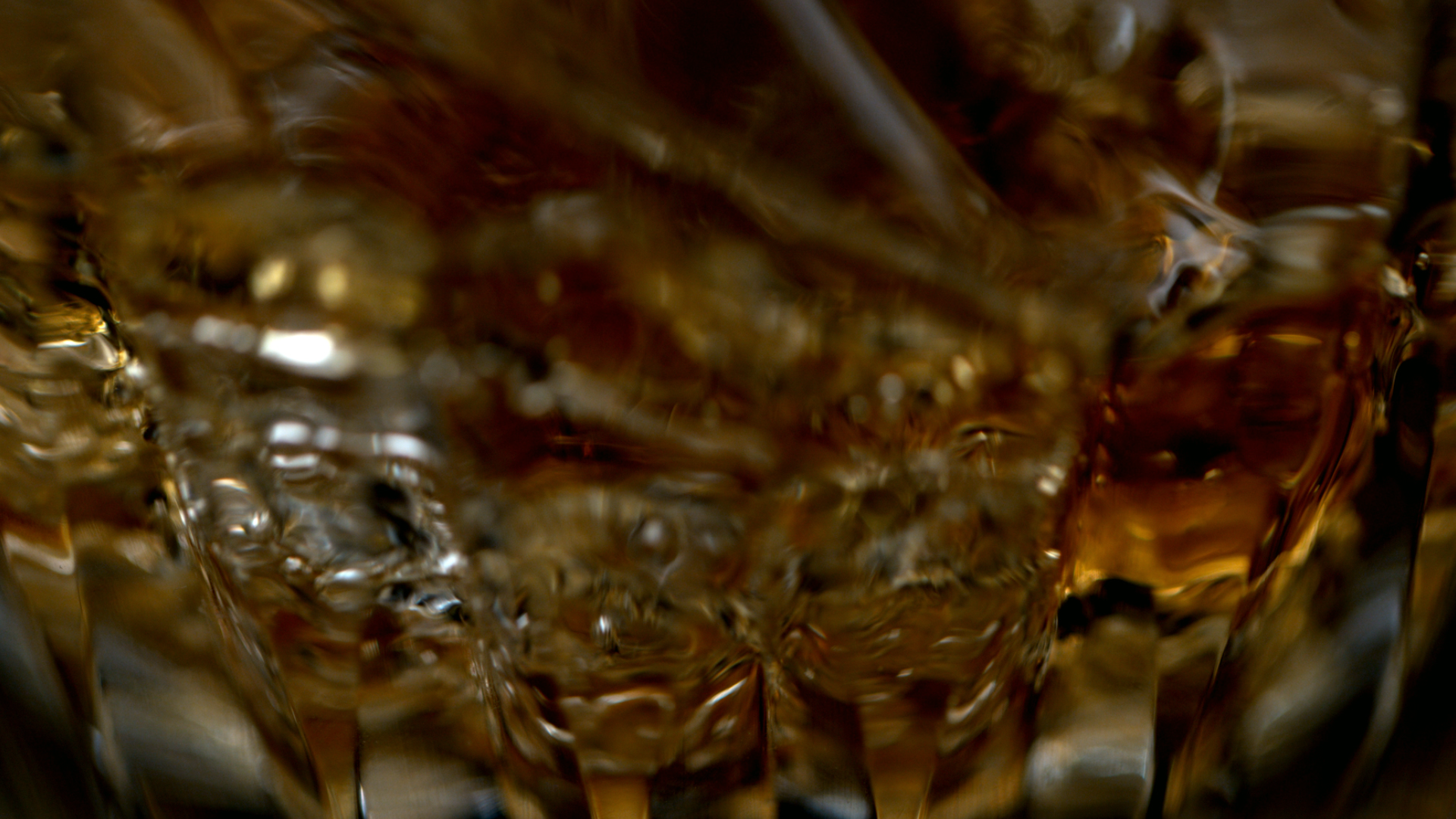 Close-up of a large block of ice with swirling golden and dark brown hues inside.