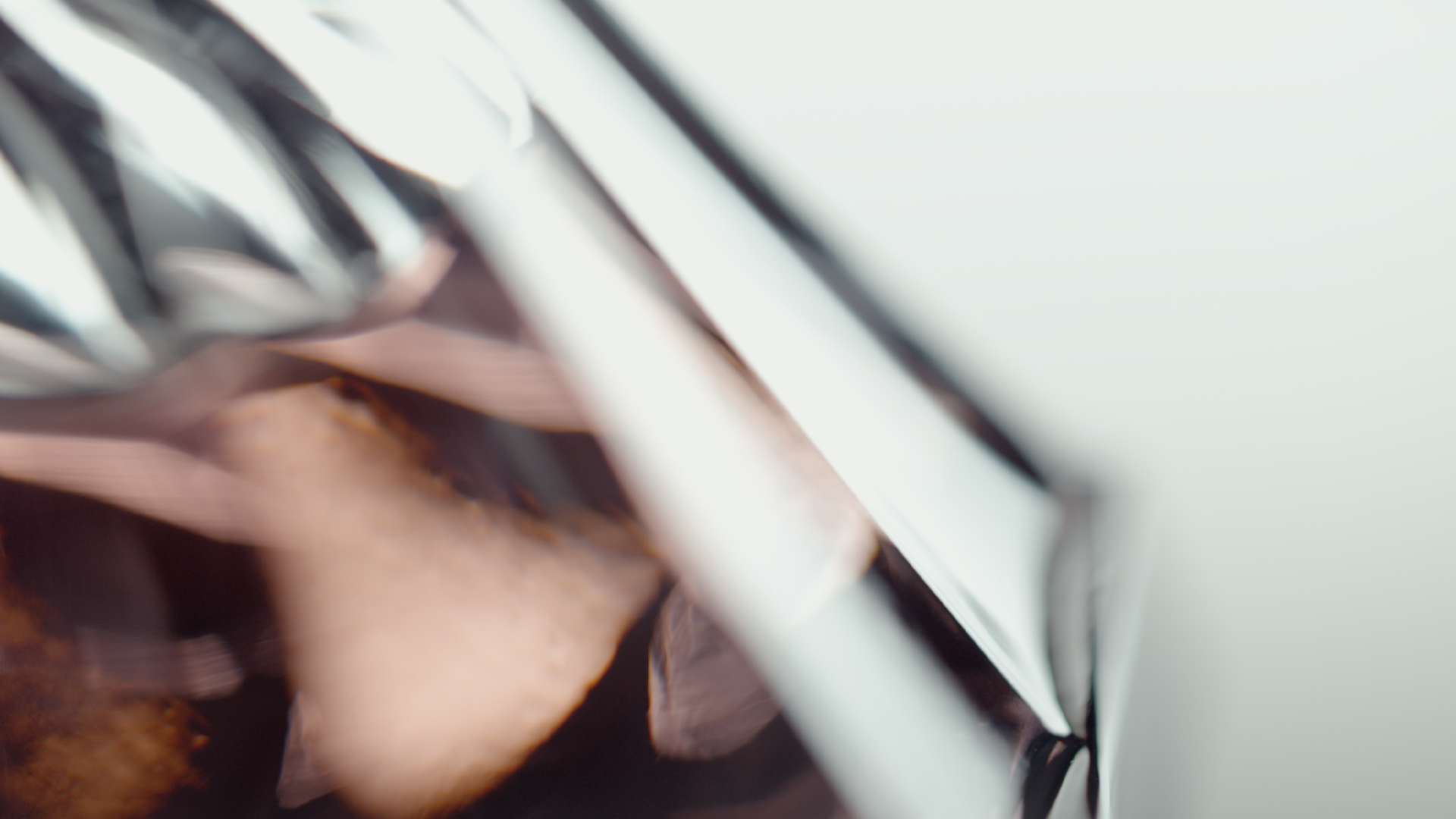 Close-up of a shiny metallic and plastic surface with some light reflections and shadows.