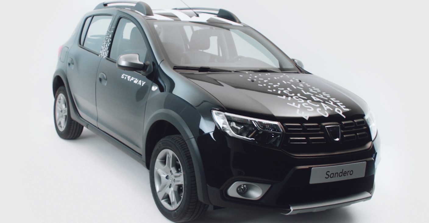 Black and gray compact SUV with the word 'STEPWAY' on the side and a model name 'Sandero' on the front license plate, featuring a graphic design on the hood with white text.
