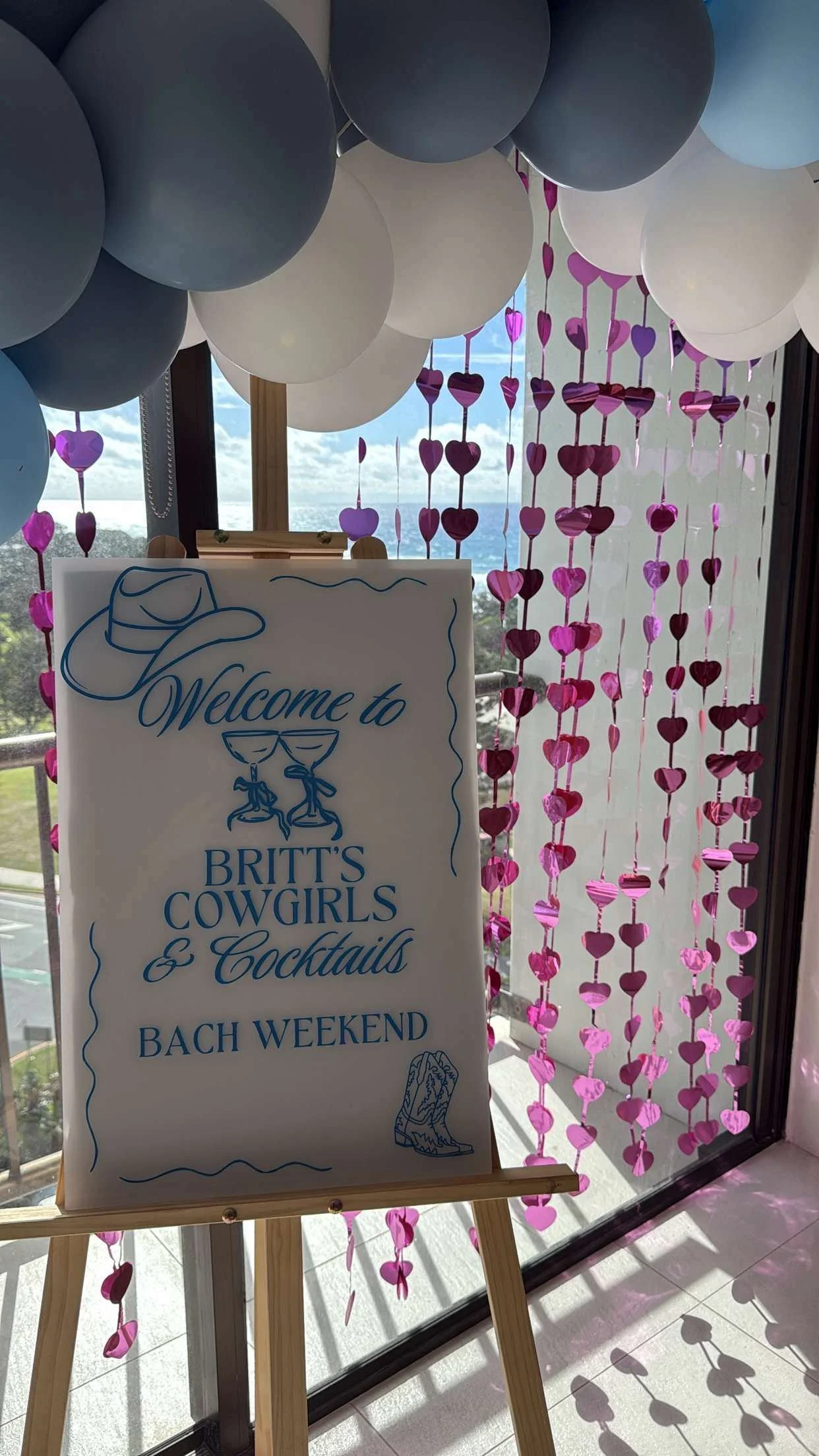 Decorative balloons and a sign welcoming guests to Britt's Cowgirls and Cocktails during a Bach weekend event.