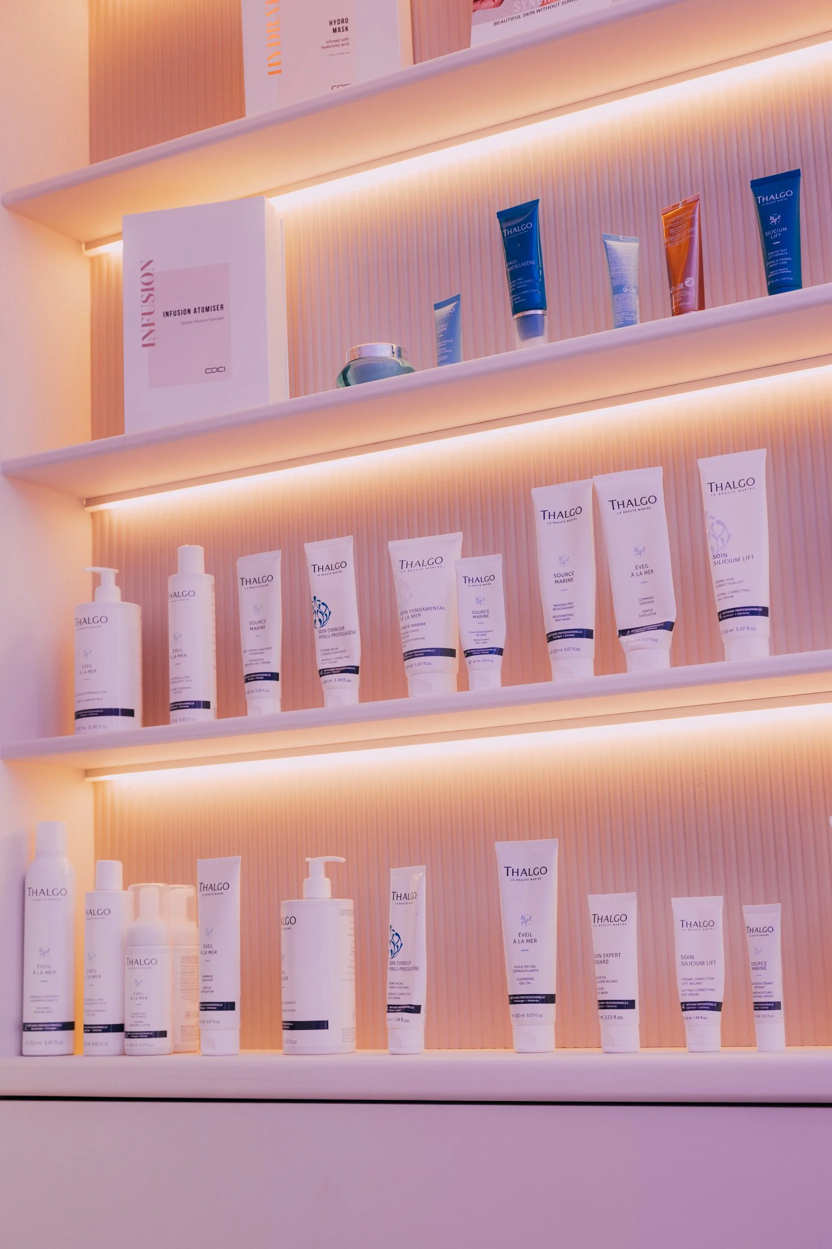 Display shelves with skincare products, including creams and lotions, illuminated by warm lighting.