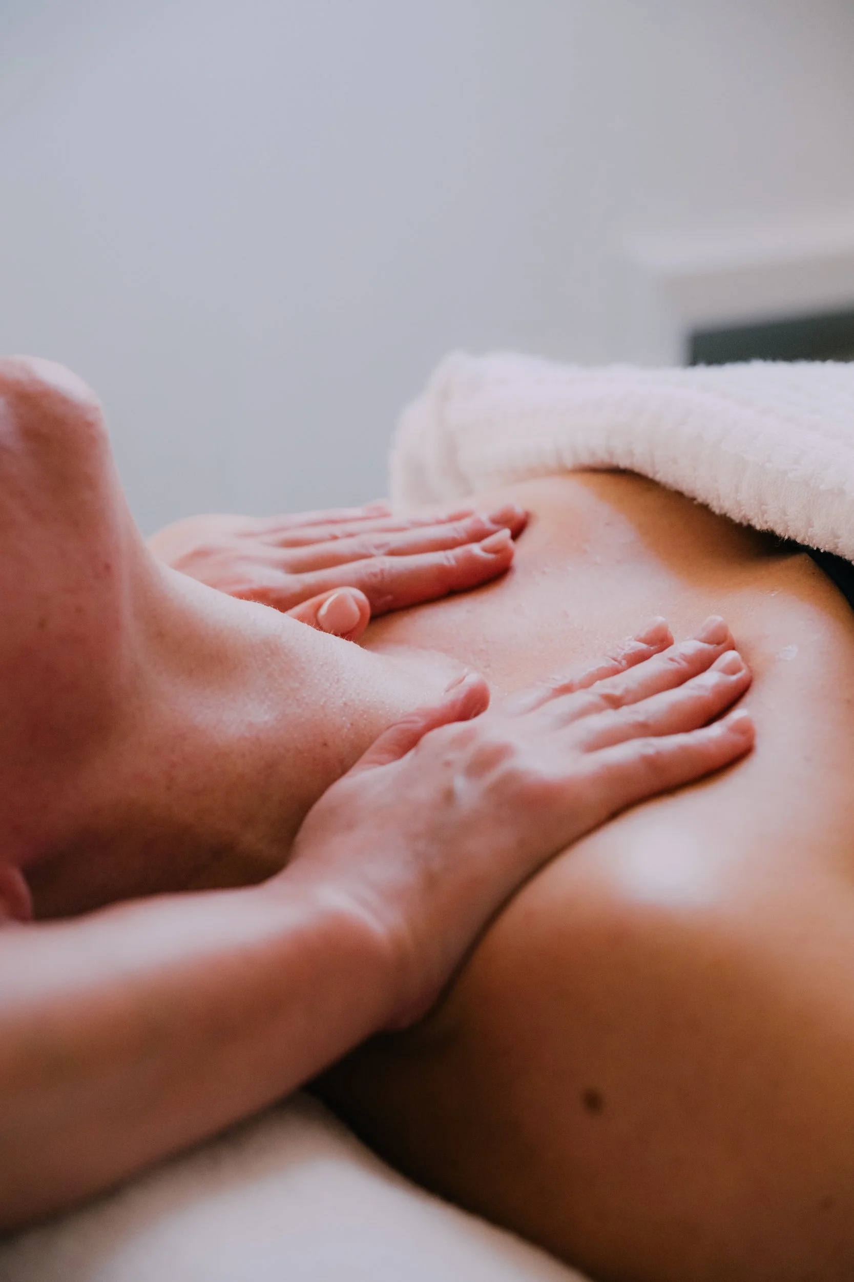A person receiving a massage on their back in a spa or massage room.