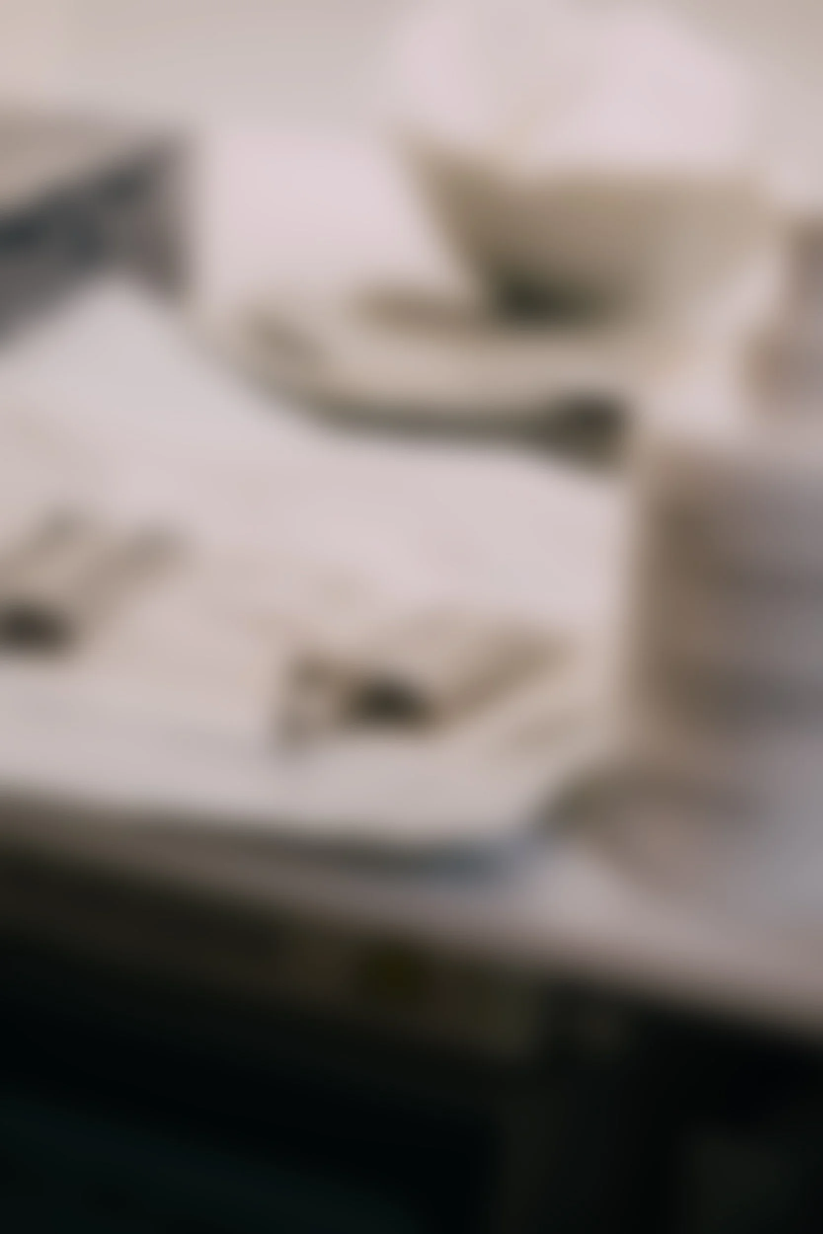 Blurred image of a stack of papers on a black surface.