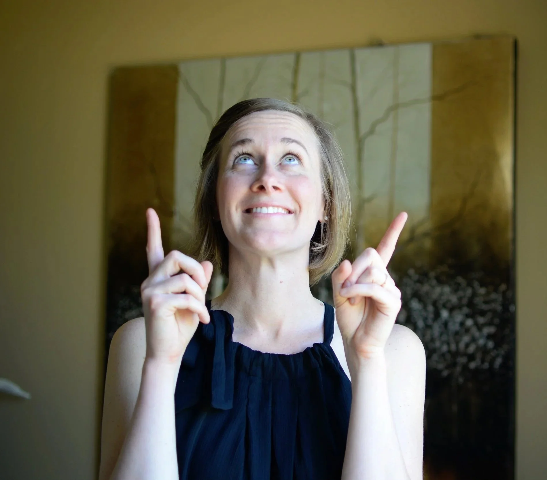 Woman looking upward with her index fingers pointing up.