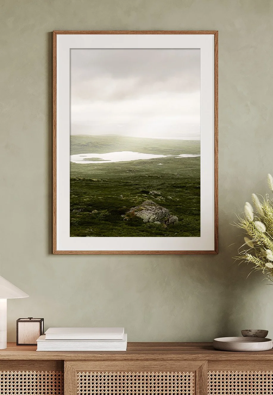Ein Wandbild eines nebelverhangenen Landschafts mit Seen, grünen Hügeln und einem großen Felsen im Vordergrund. Motiv entstand im Hardangervidda, Norwegen