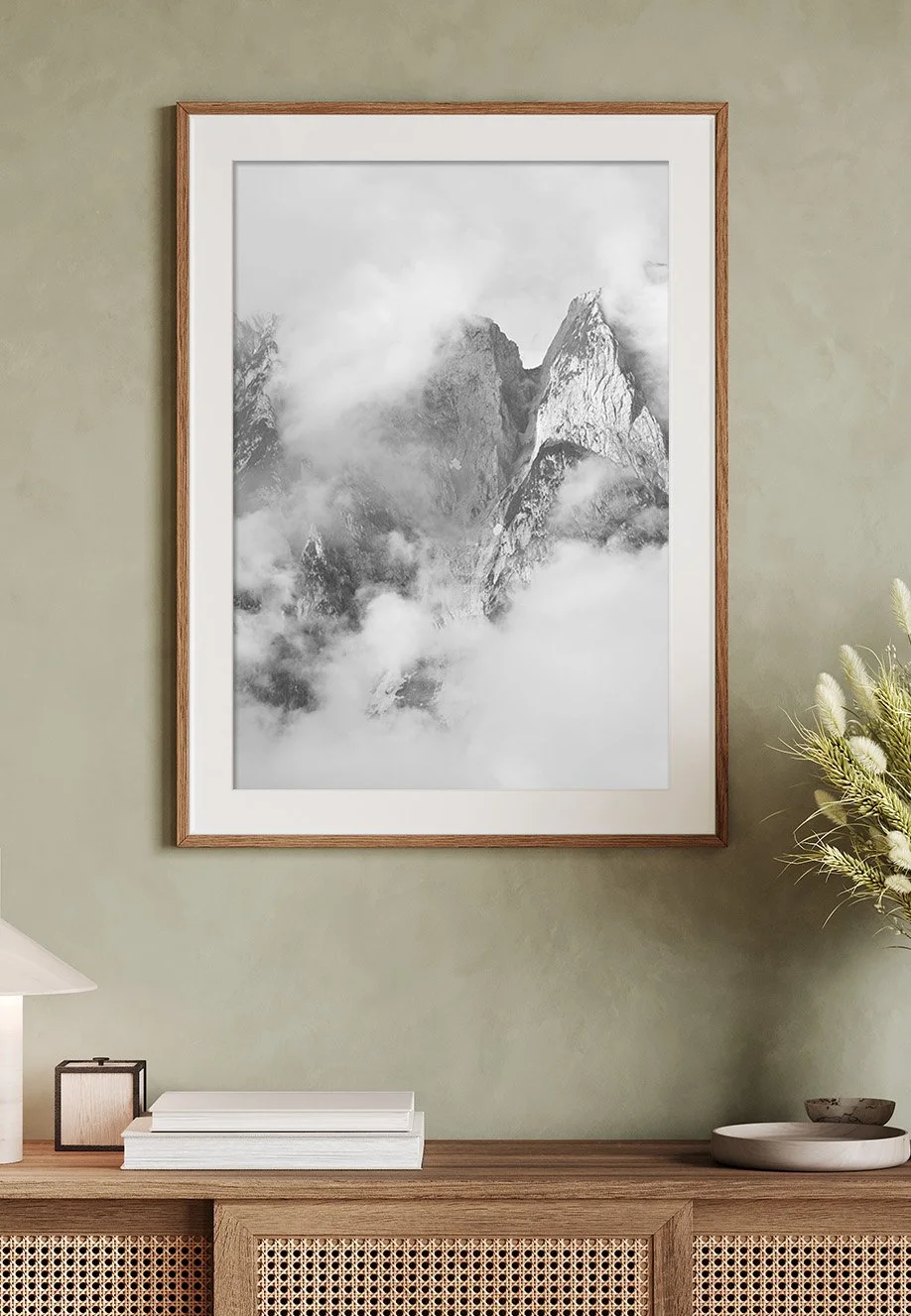 Schwarz-weiße Fotografie des Gosaukamms, einer Bergkette in Österreich. Berggipfeln in Wolken, gerahmt an einer Wand. 